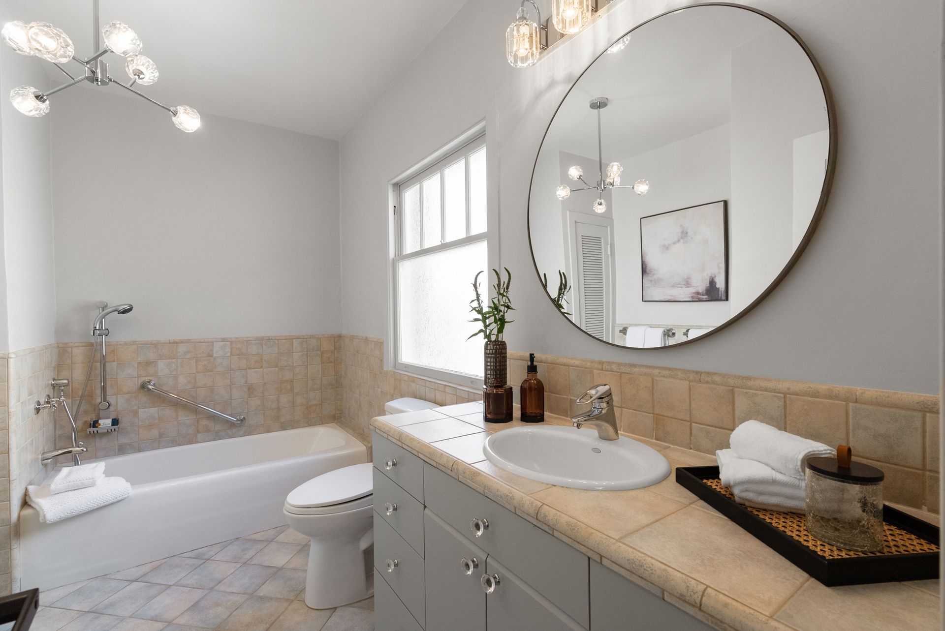 A bathroom with a sink , toilet , tub and mirror