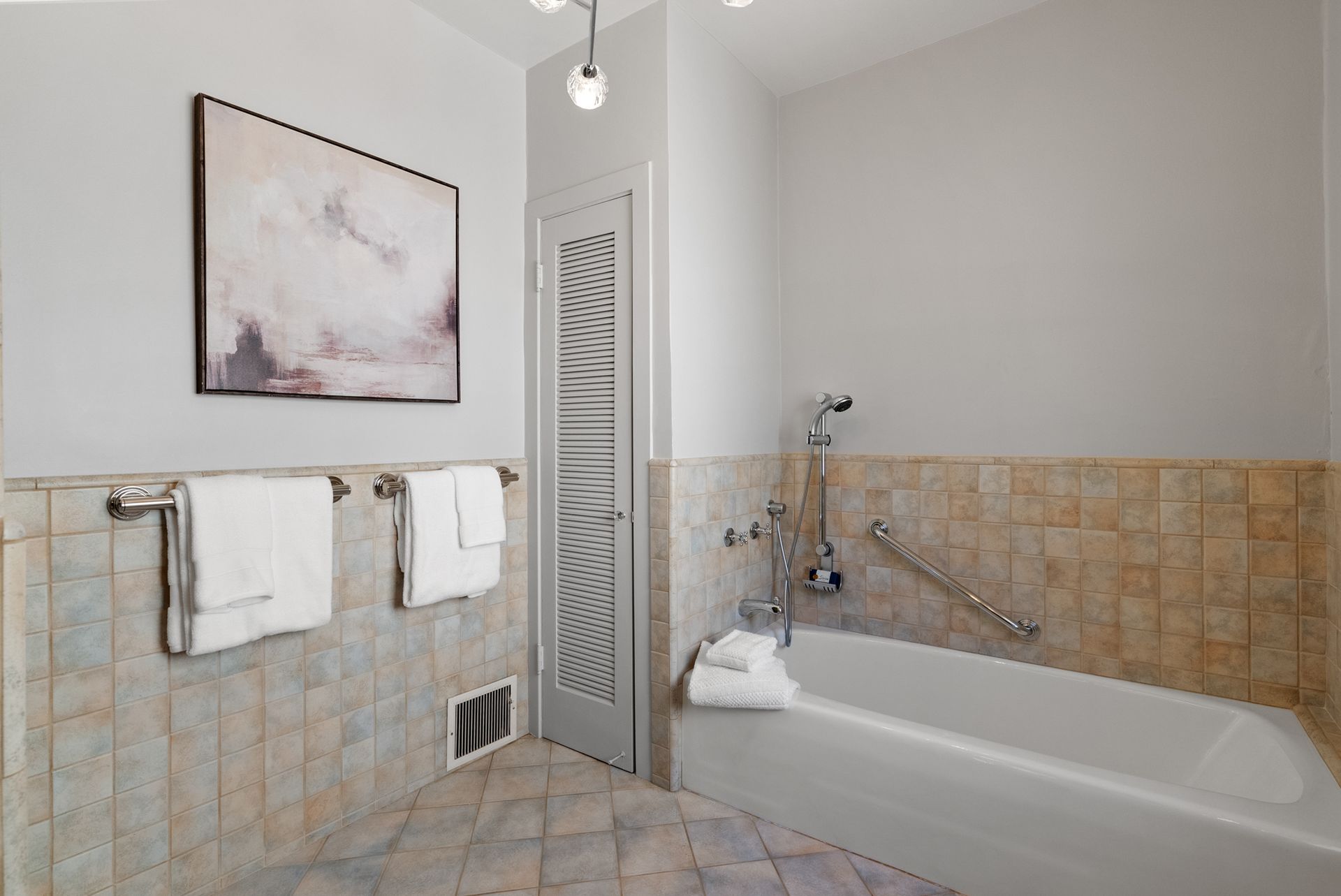 A bathroom with a tub and a picture on the wall.