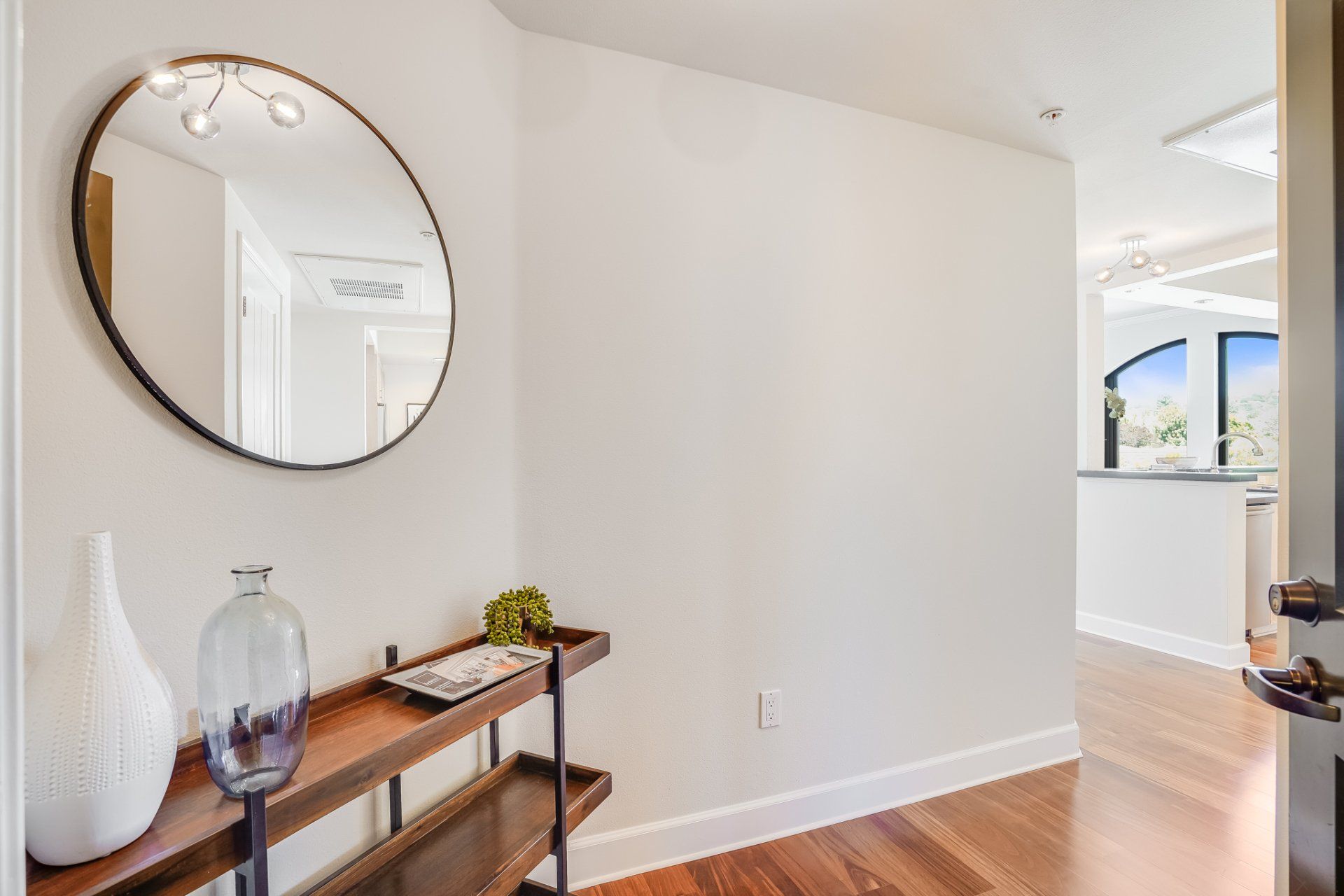 A hallway with a round mirror on the wall