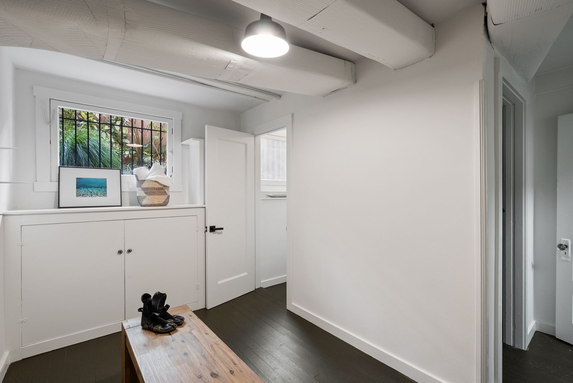A hallway with a bench and a painting on the wall
