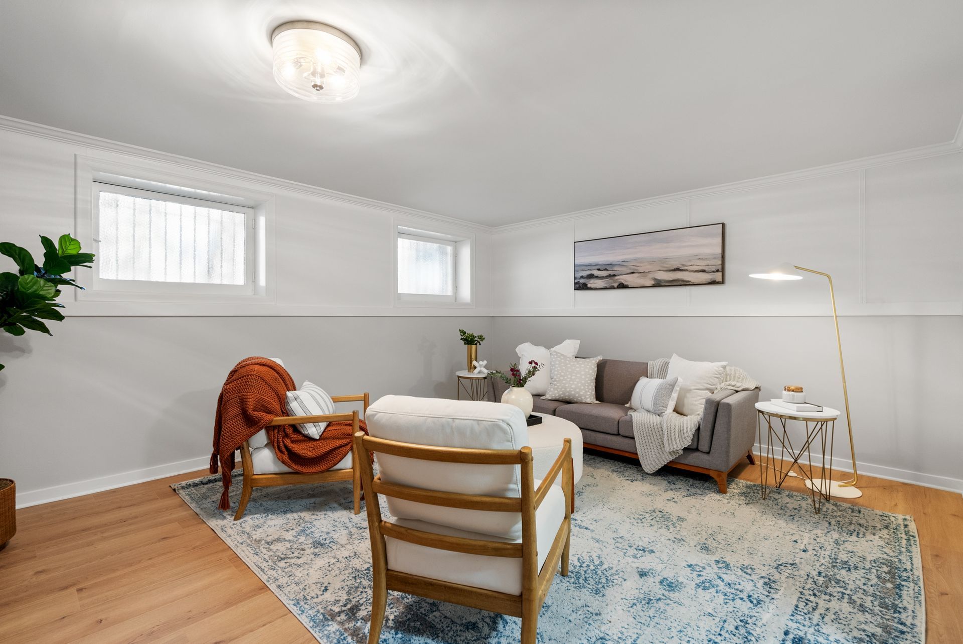 A living room with a couch , chairs , and a rug.