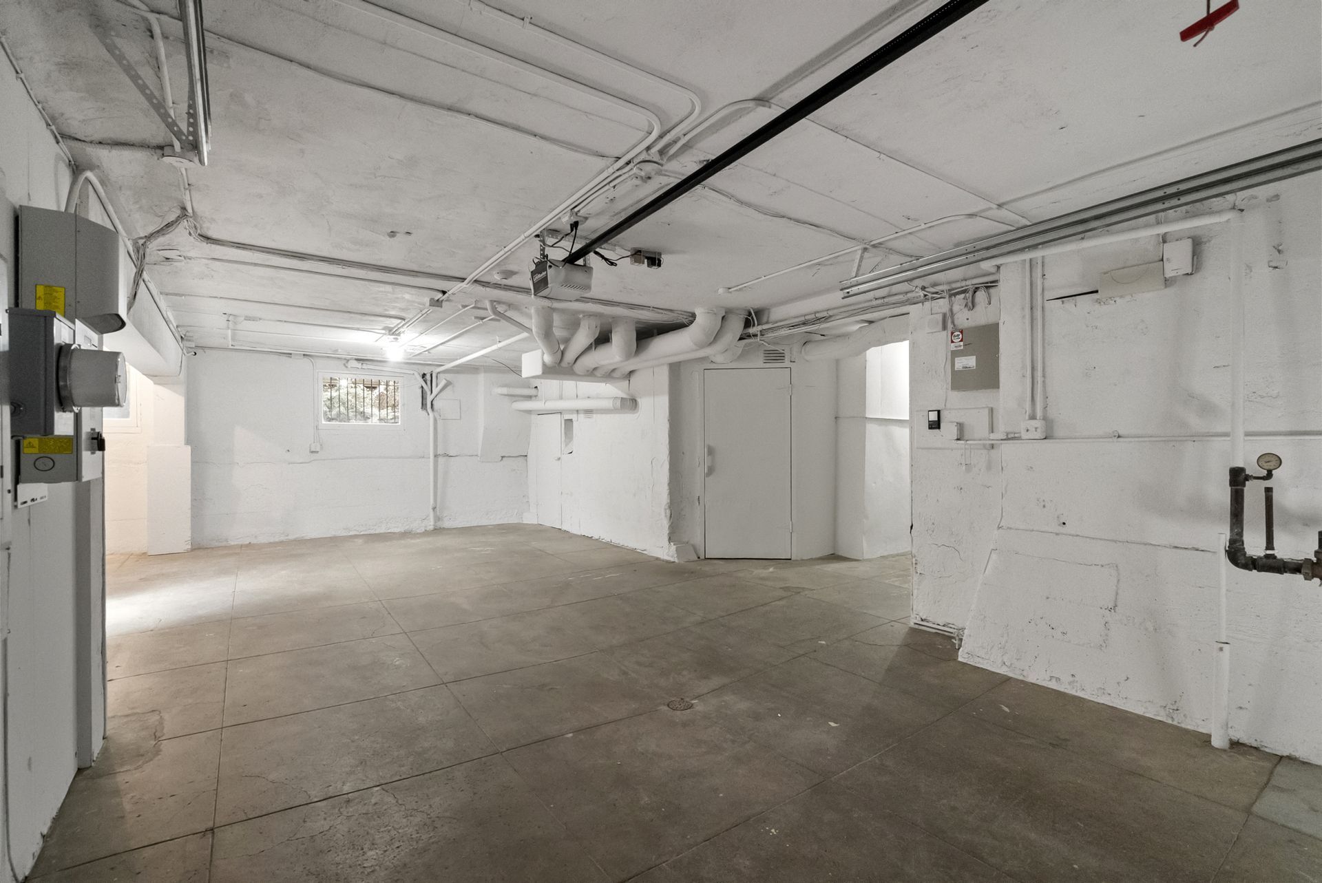 An empty garage with white walls and a concrete floor.