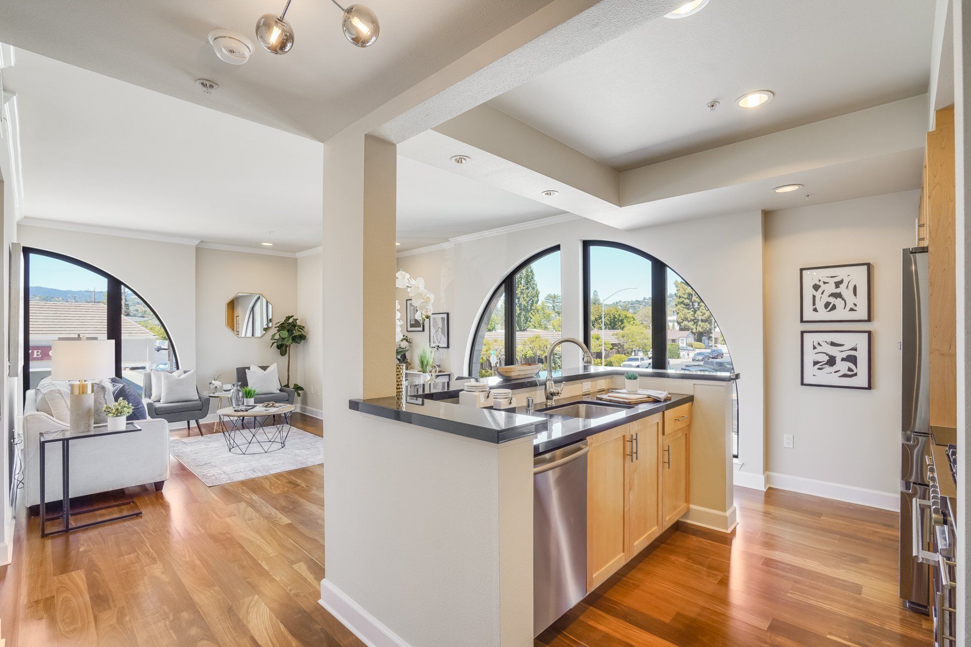 A kitchen with stainless steel appliances and hardwood floors in a house.