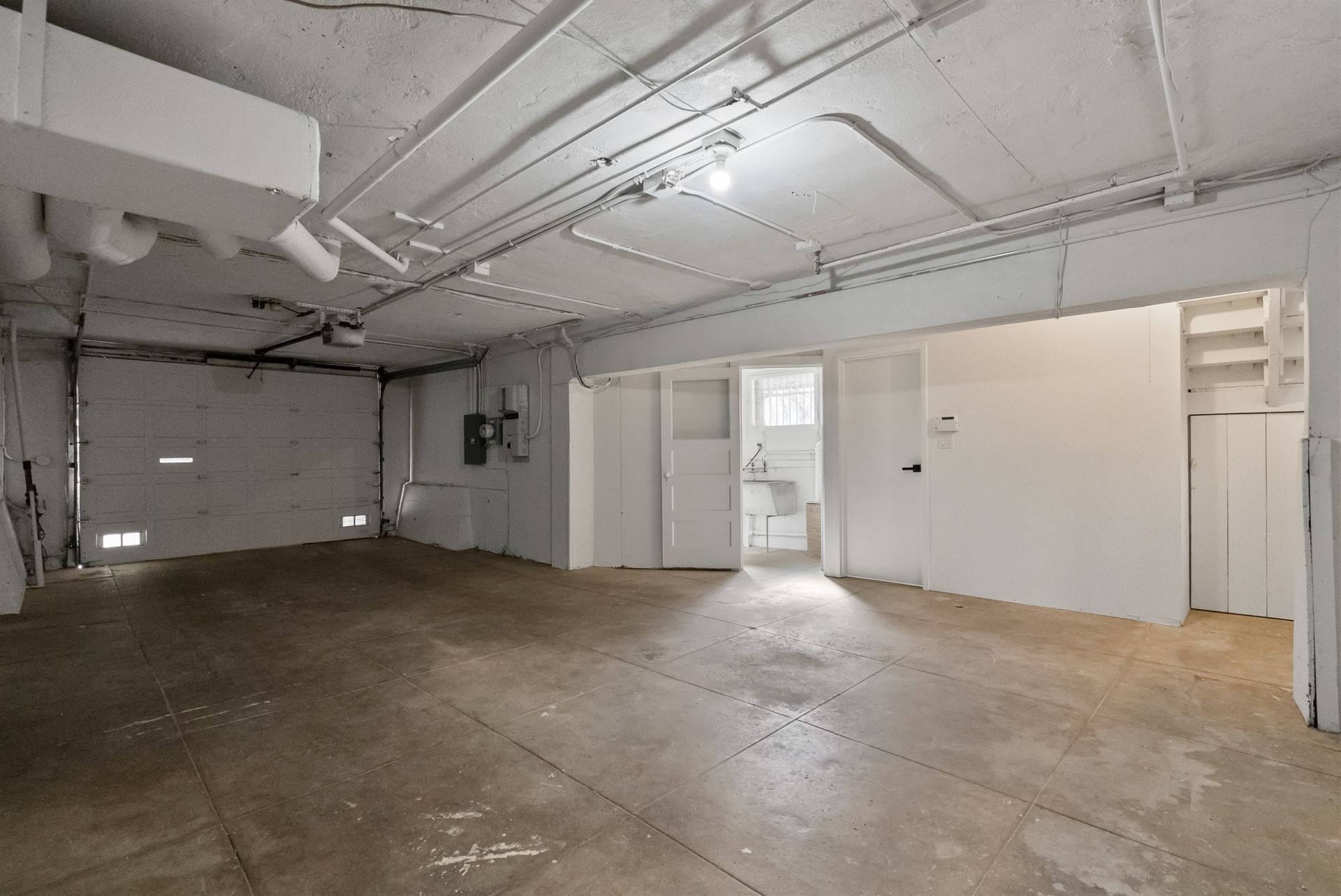 An empty garage with a door and a closet.
