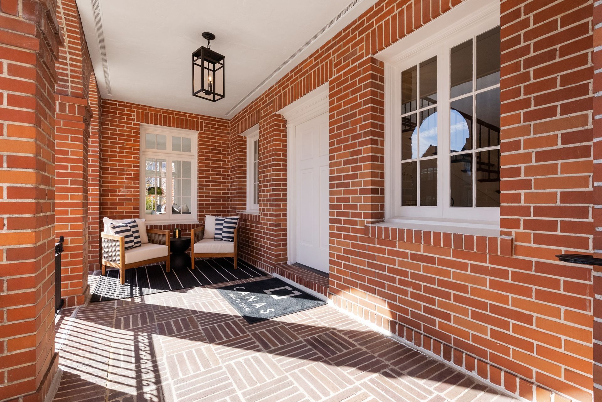 A brick porch with chairs and a table