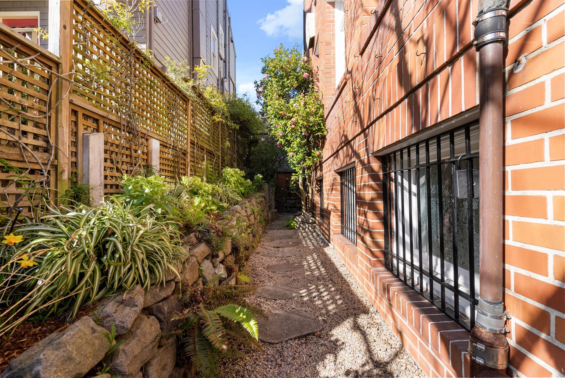 A brick building with a fence and a walkway leading to it.