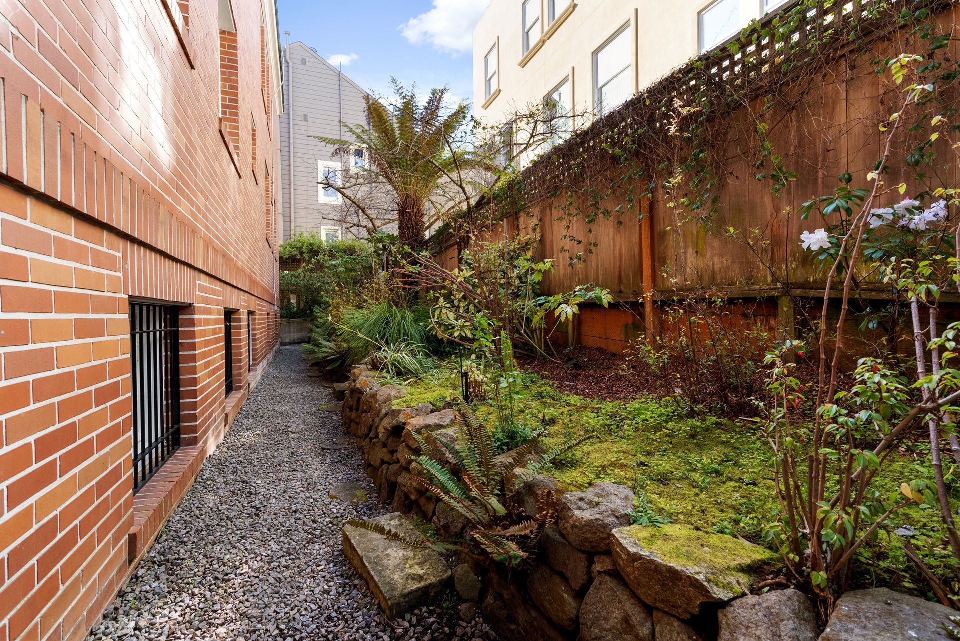 A brick building with a garden in front of it.