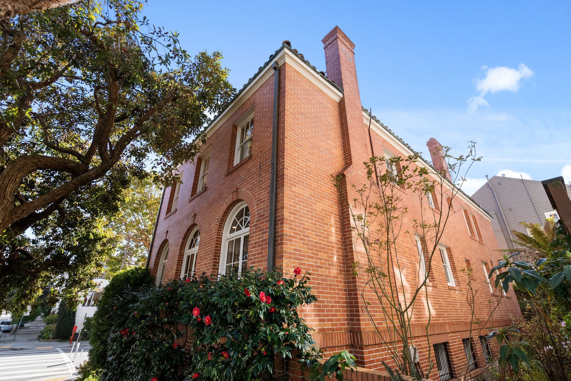 A large red brick building with a tree in front of it