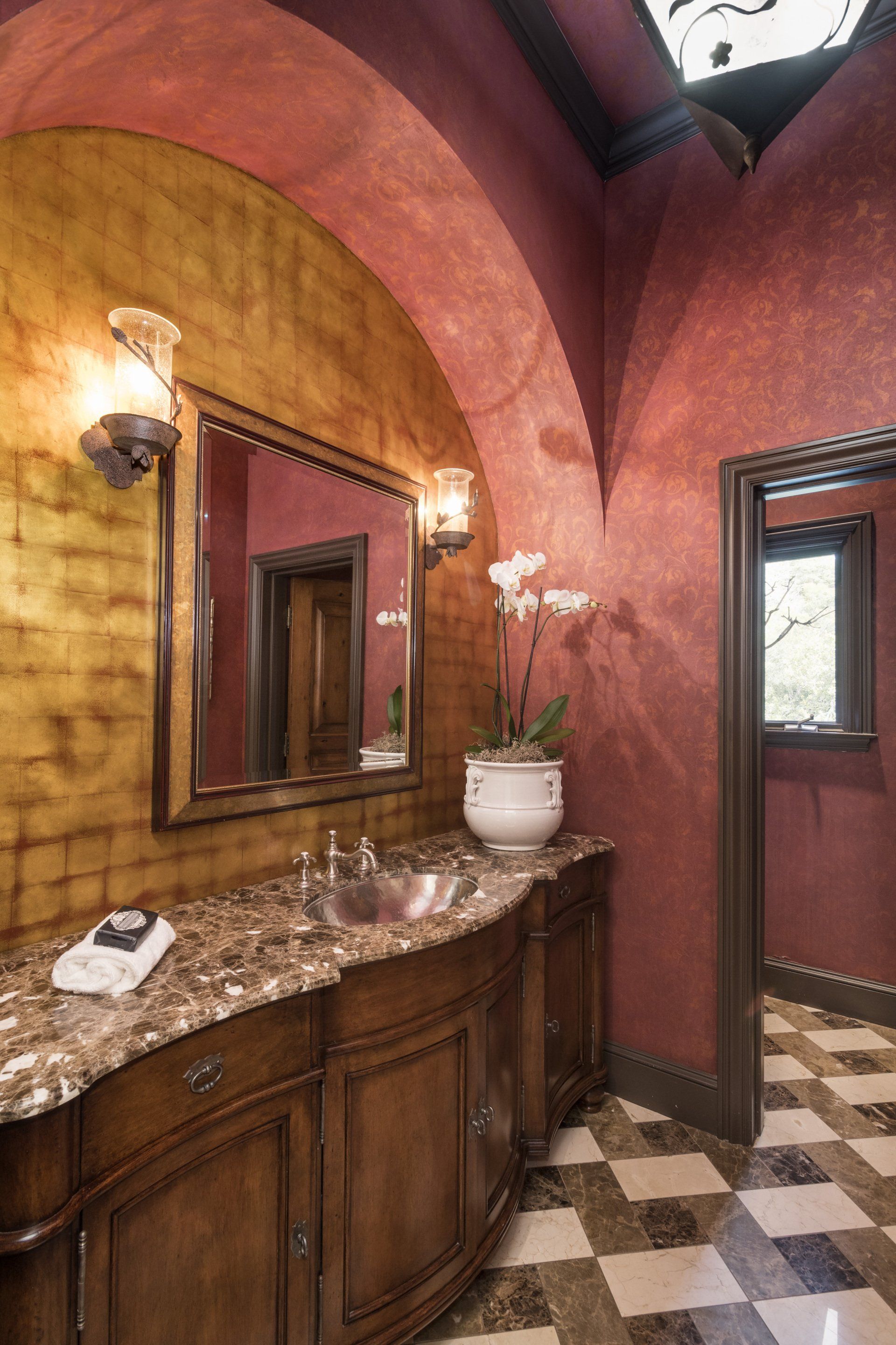 A bathroom with red walls and a checkered floor