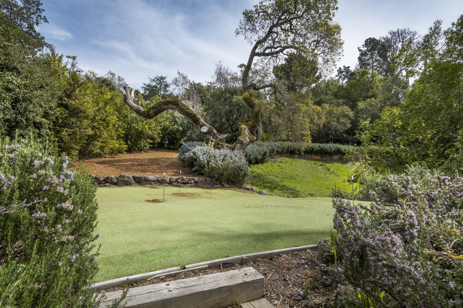 There is a bench in the foreground and a golf course in the background.