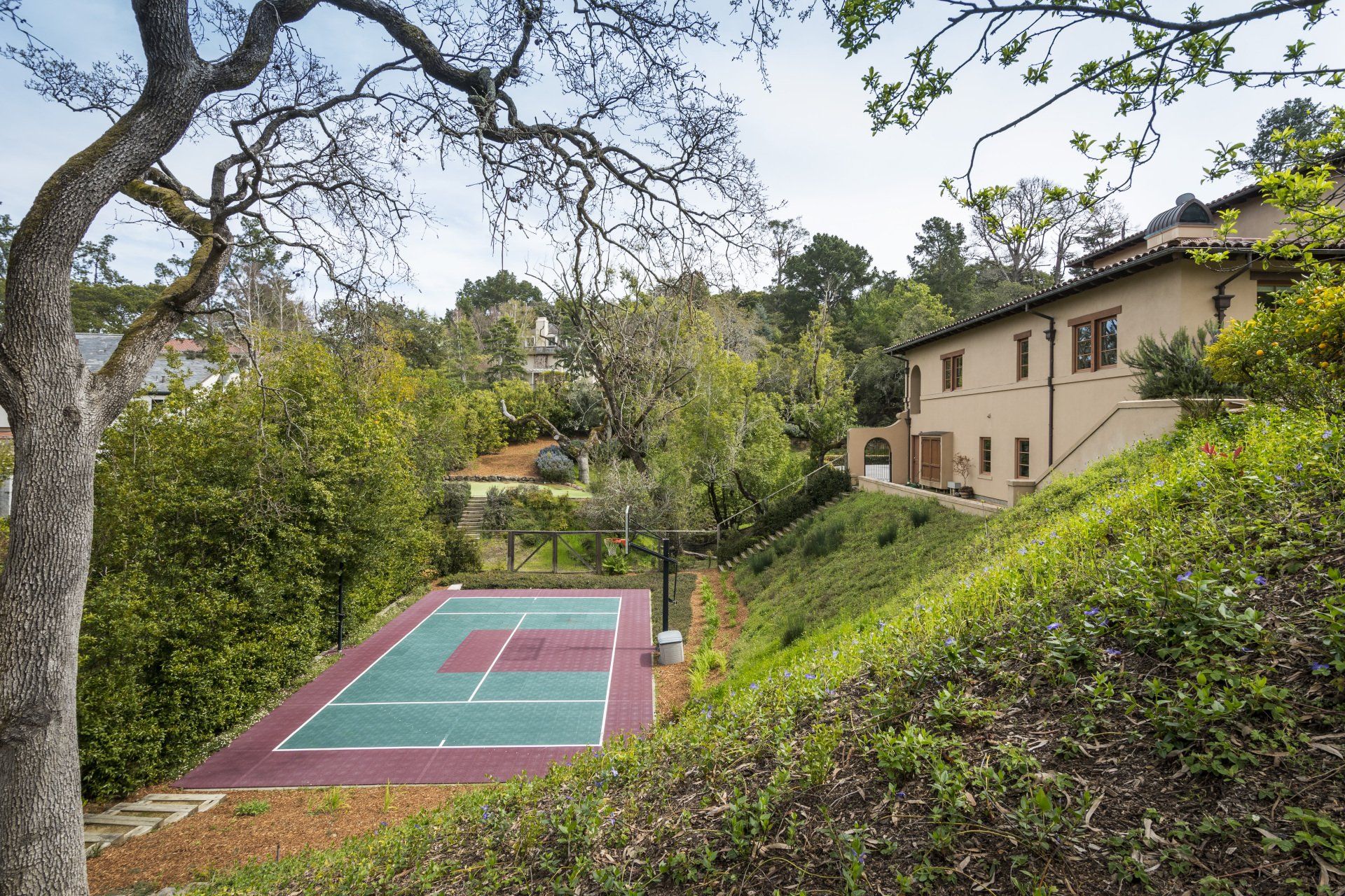A tennis court with a house in the background