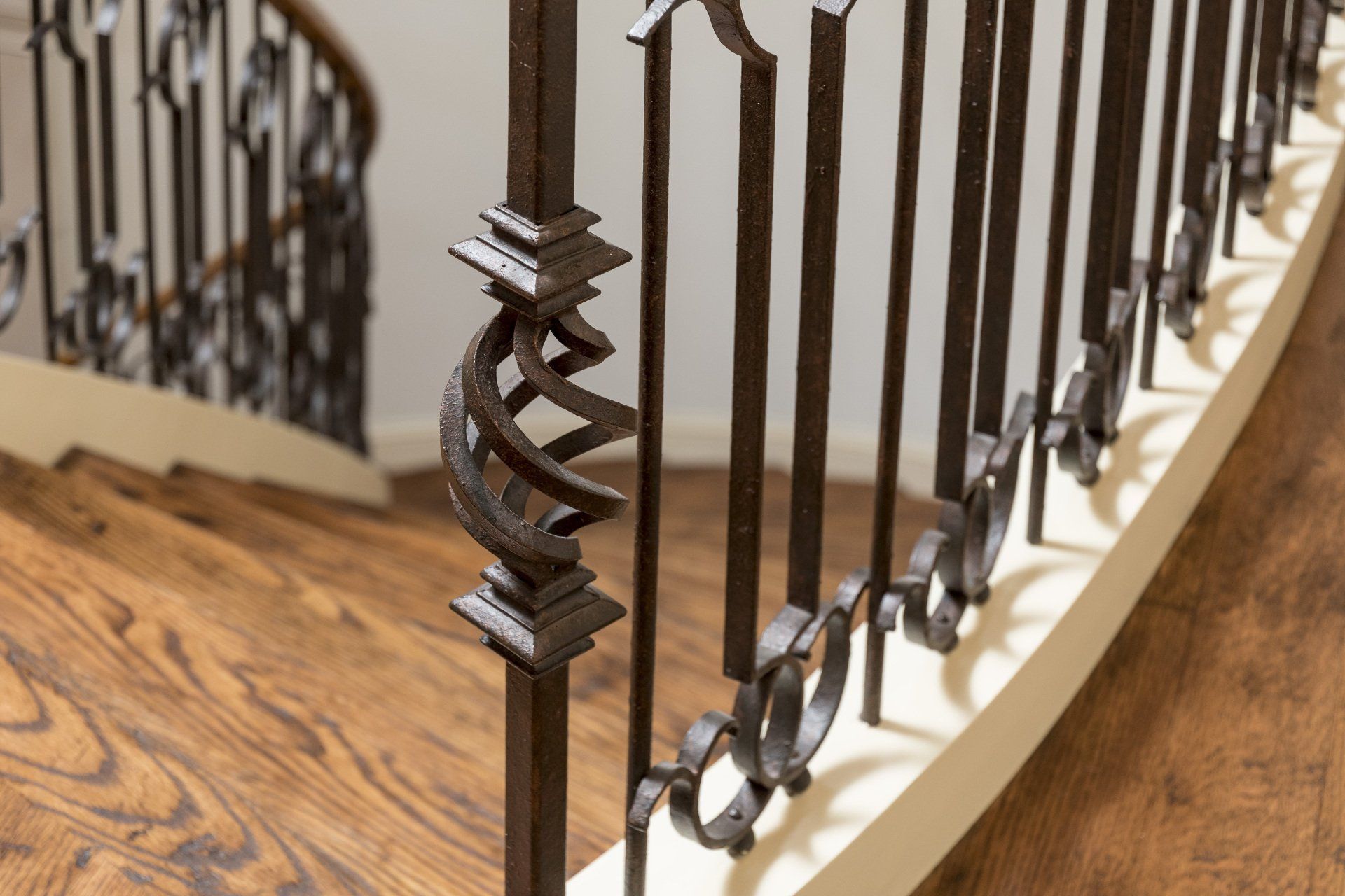 A close up of a wrought iron railing on a curved staircase.