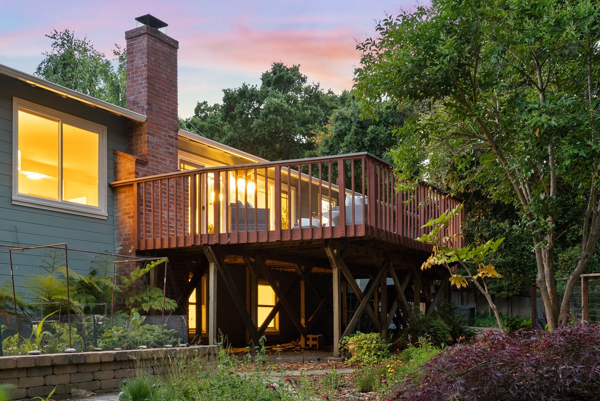 A house with a large deck and a brick chimney.