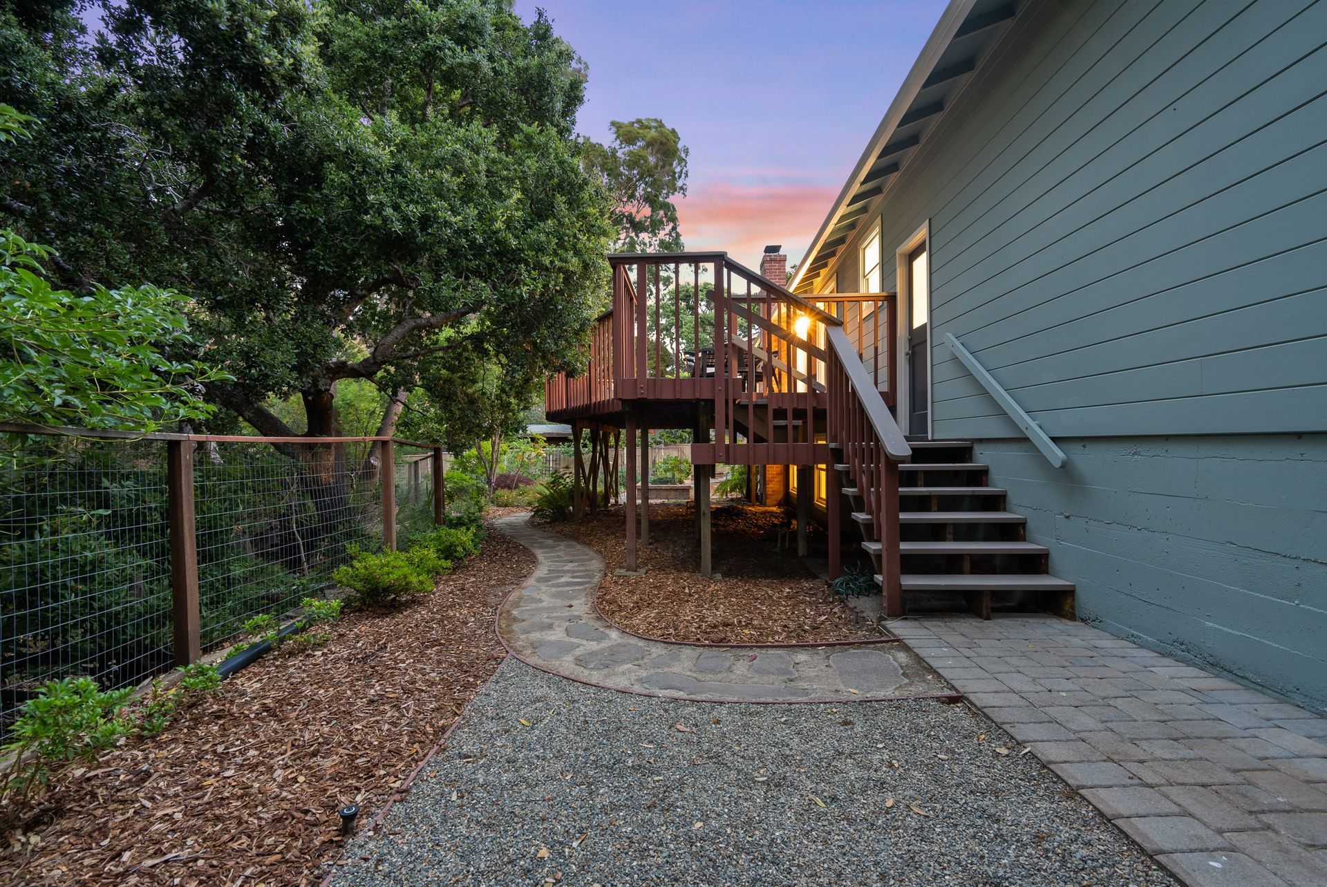 A house with a large deck and stairs leading up to it.