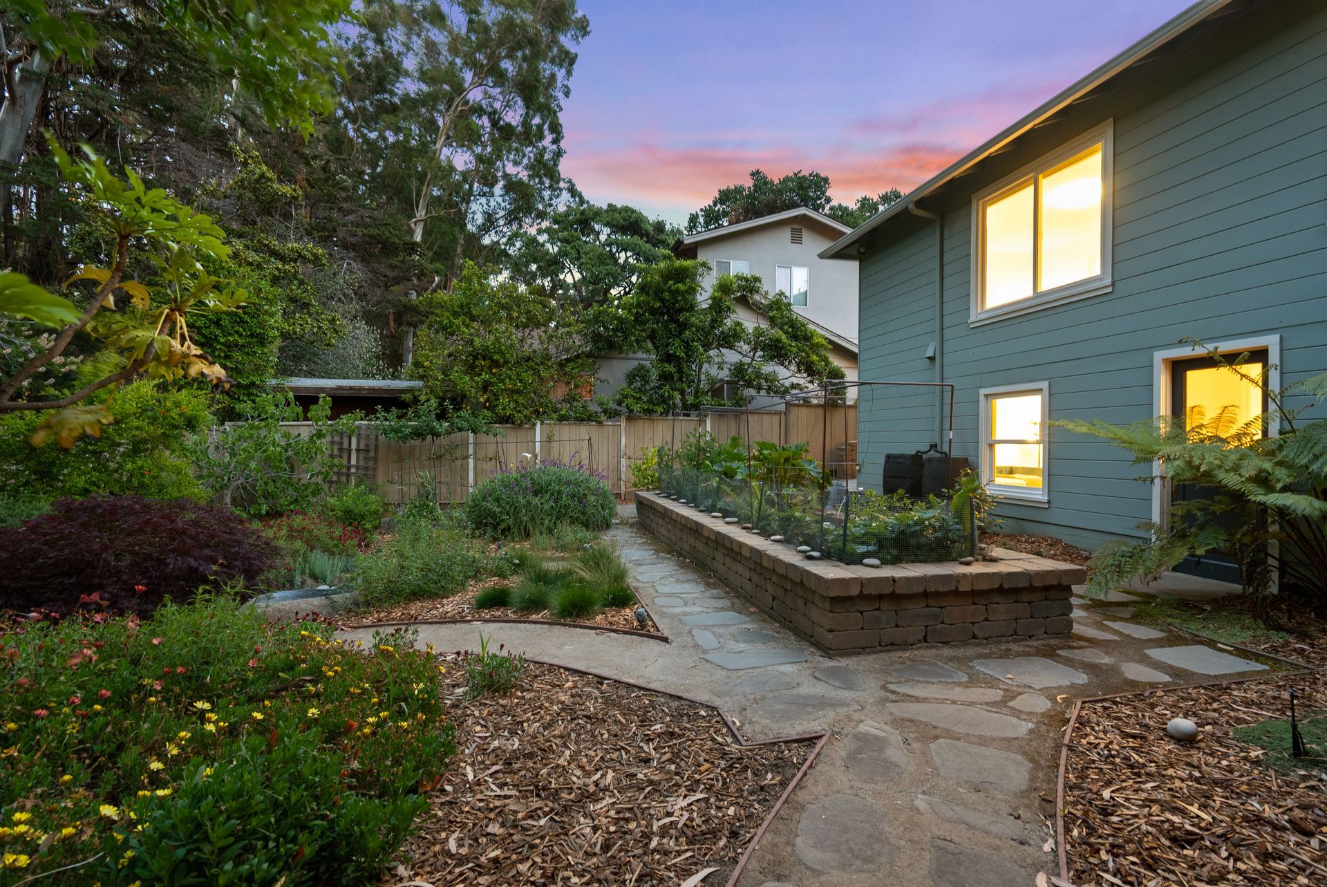A house with a garden and a walkway leading to it.