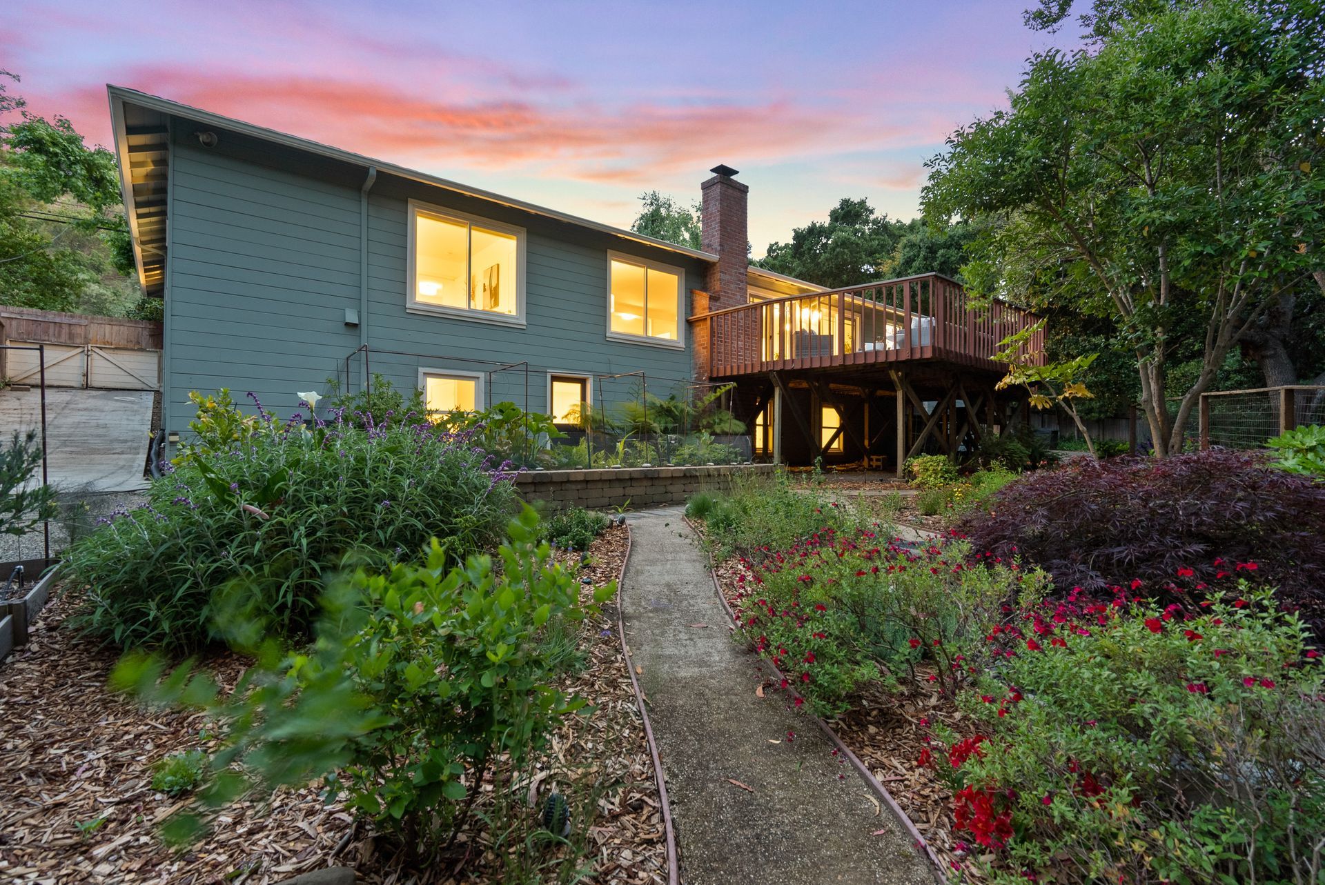 A large house with a large deck and a walkway leading to it.