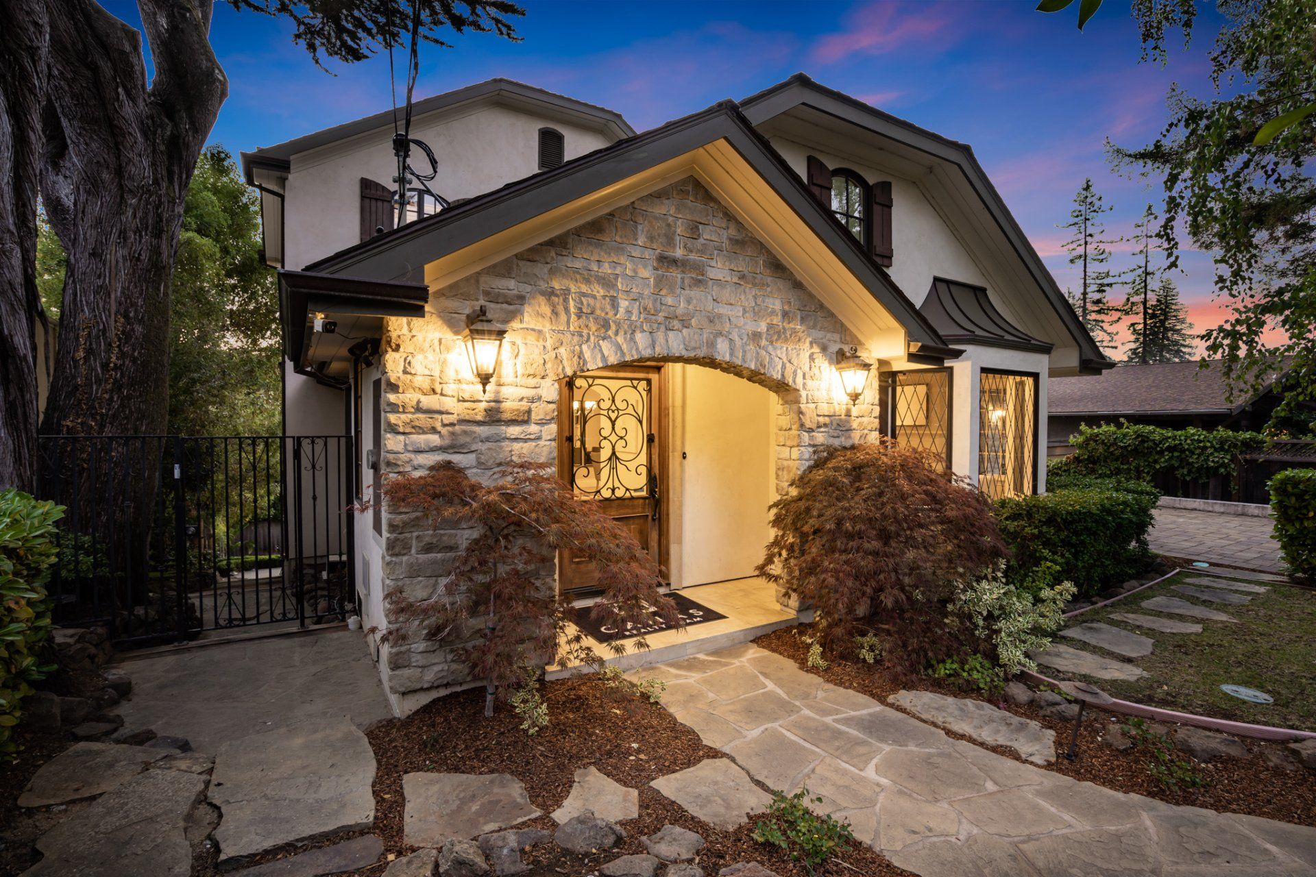 The front of a house with a stone walkway leading to it.