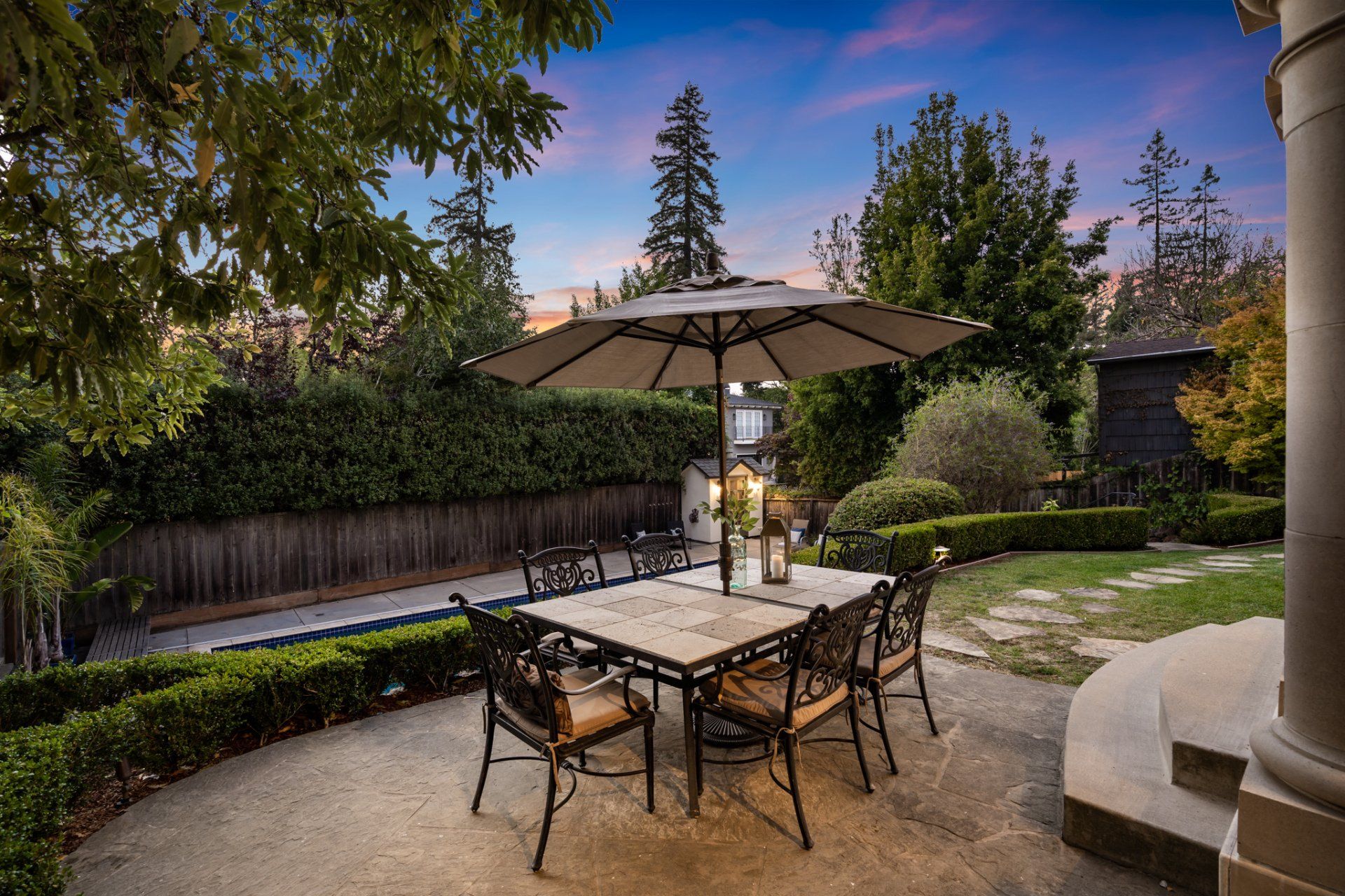 A patio with a table and chairs and an umbrella.