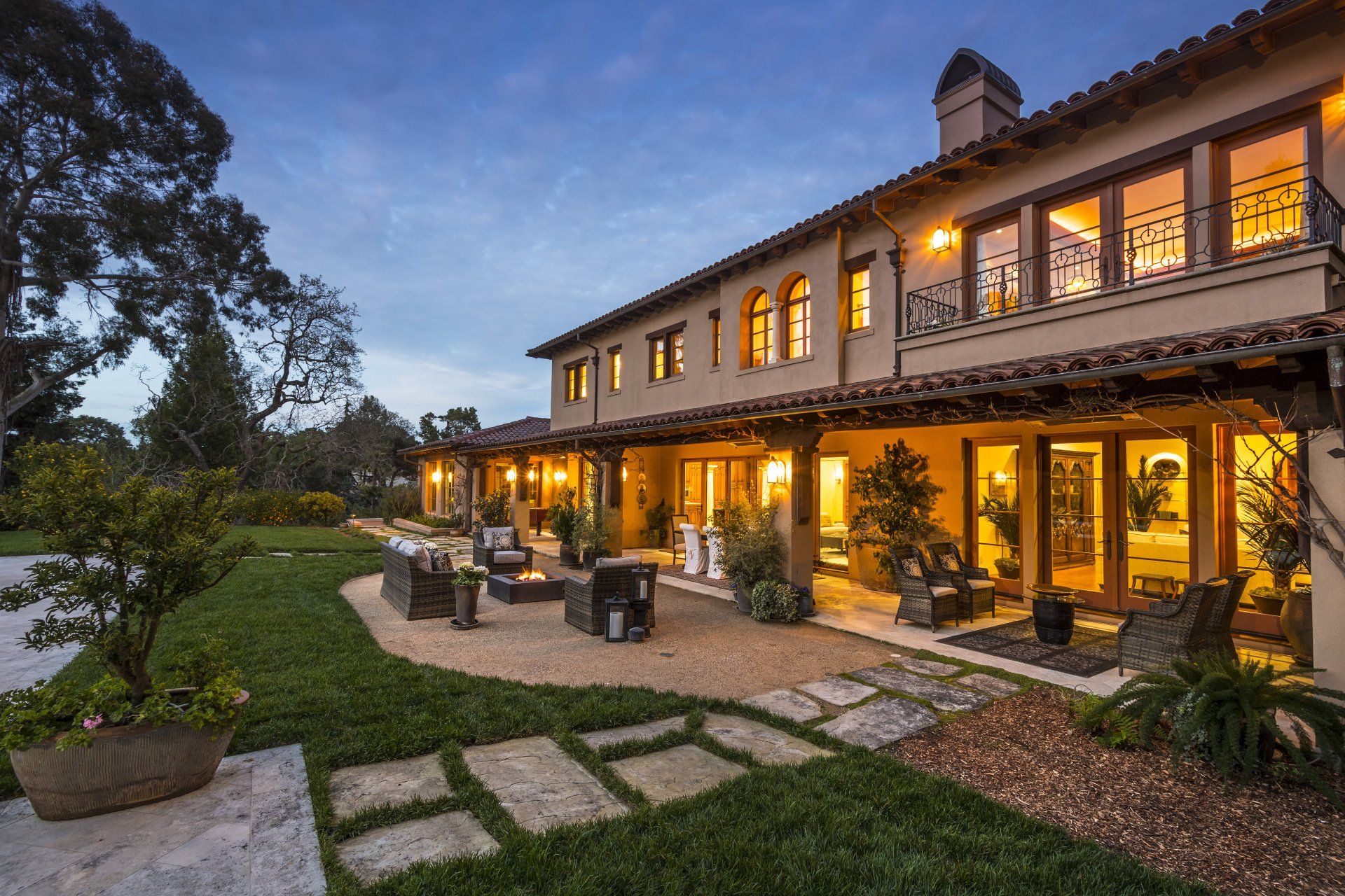 A large house with a lot of windows is lit up at night