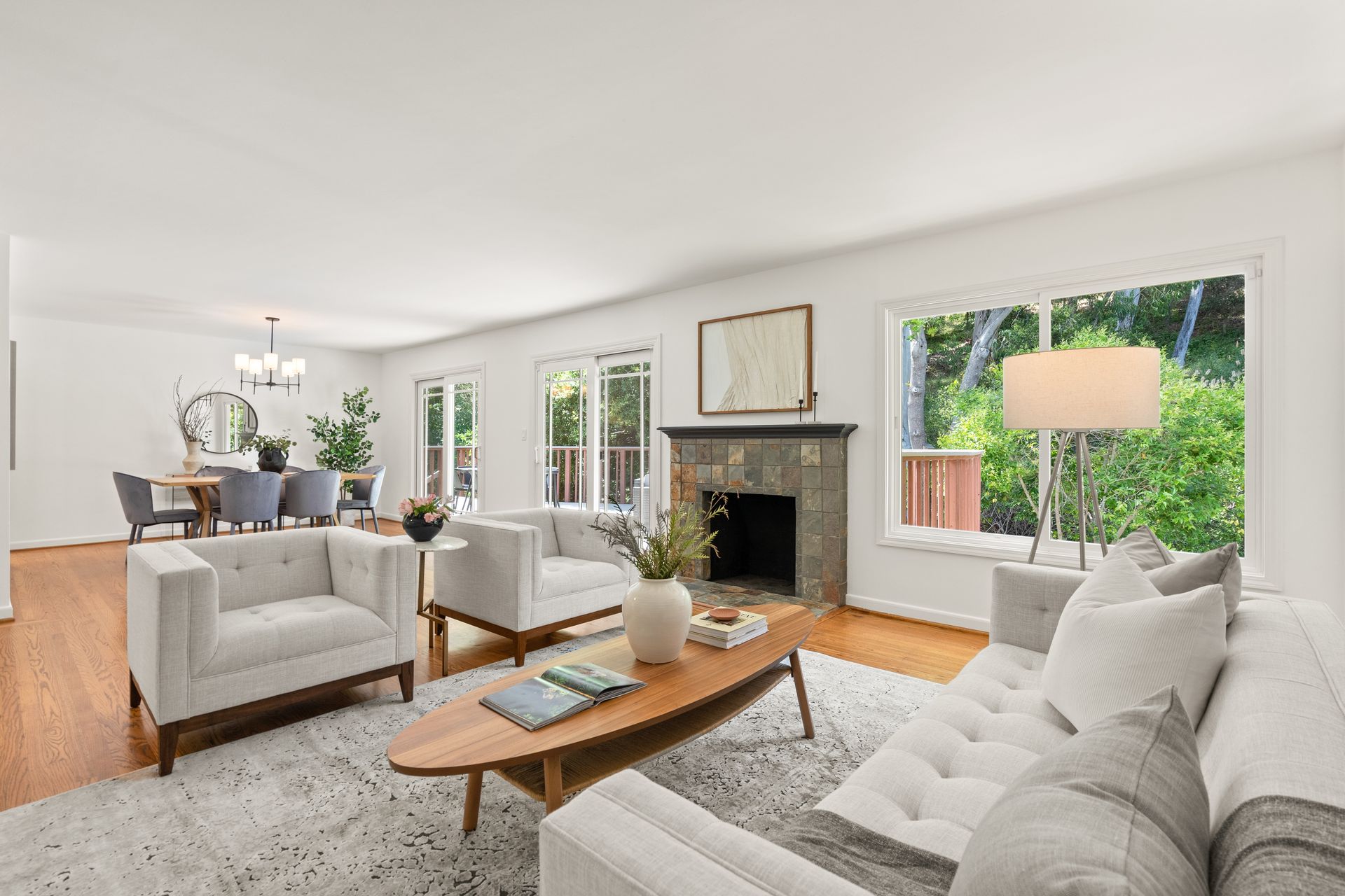 A living room with a couch , chairs , coffee table and fireplace.