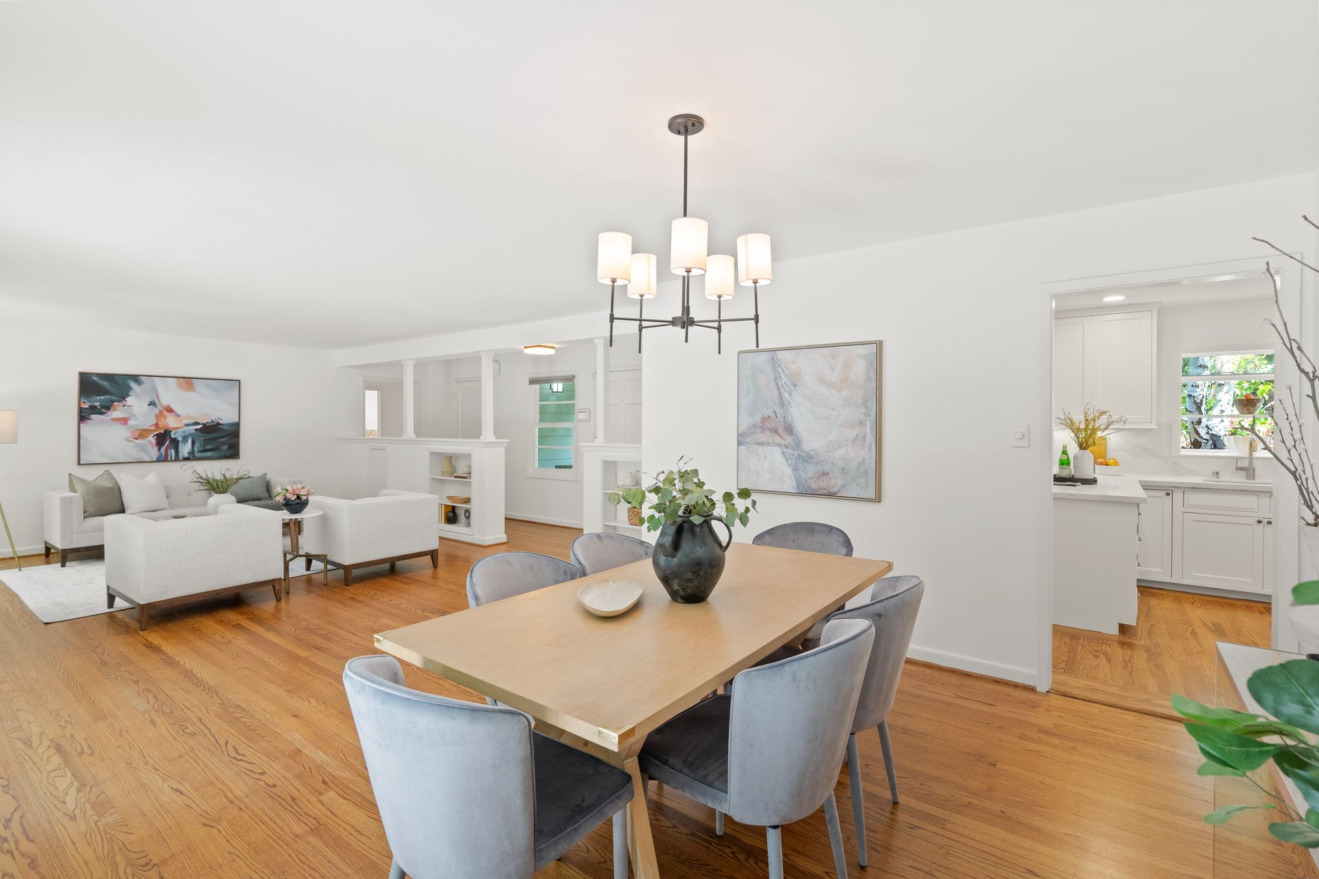 A dining room with a wooden table and chairs and a chandelier.