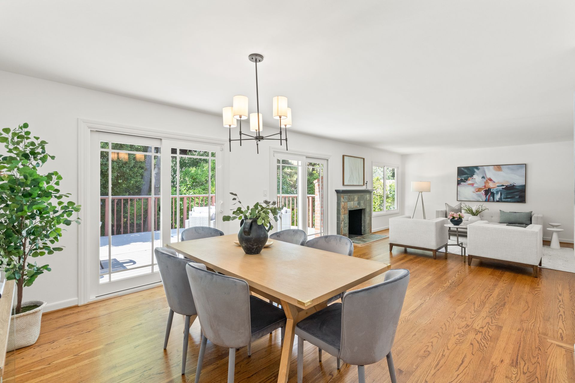 A dining room with a wooden table and chairs and a chandelier.
