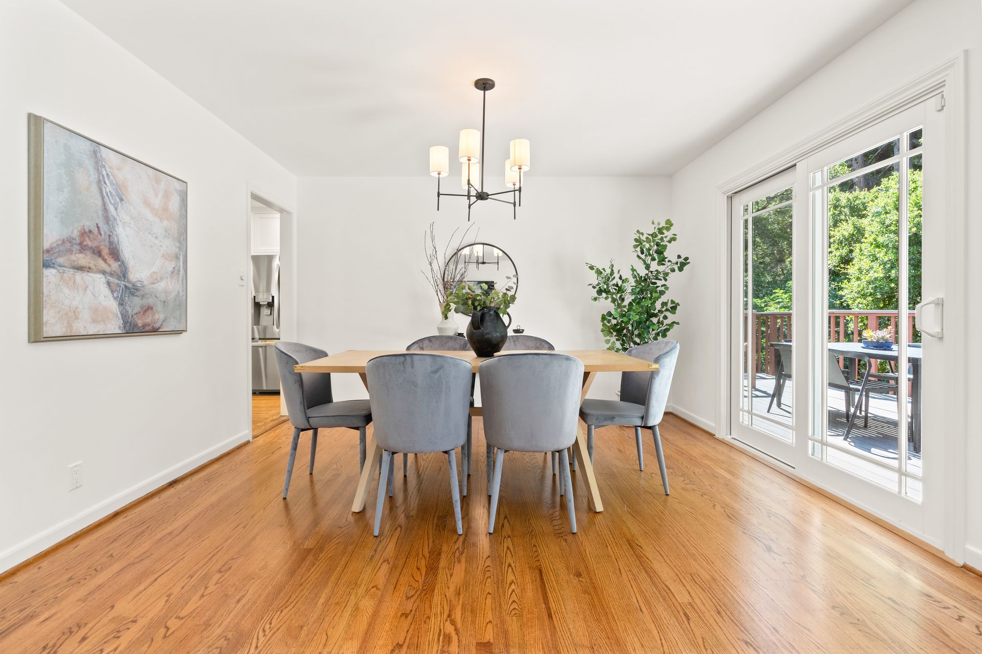 A dining room with a table and chairs and sliding glass doors