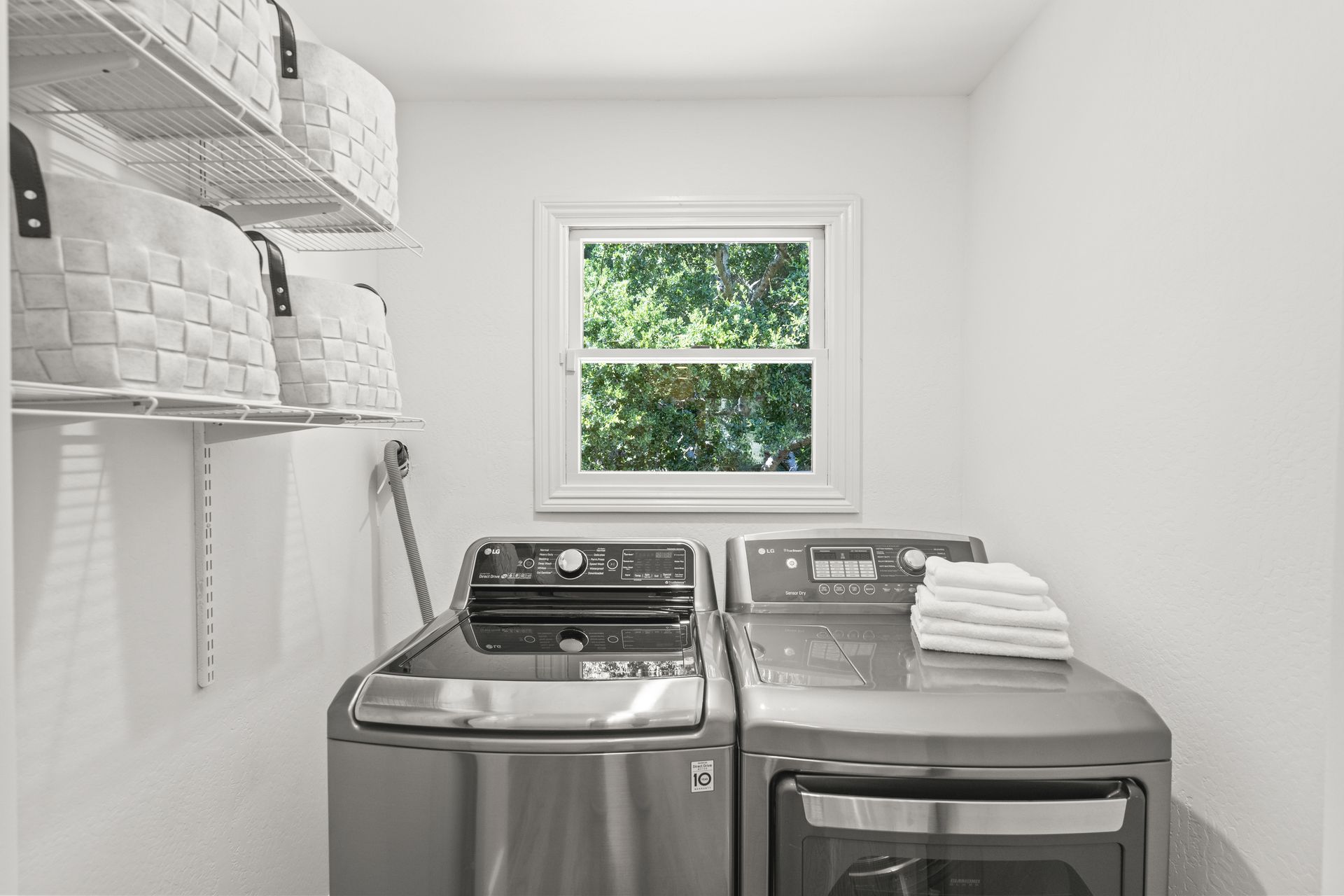 A laundry room with a washer and dryer and a window.