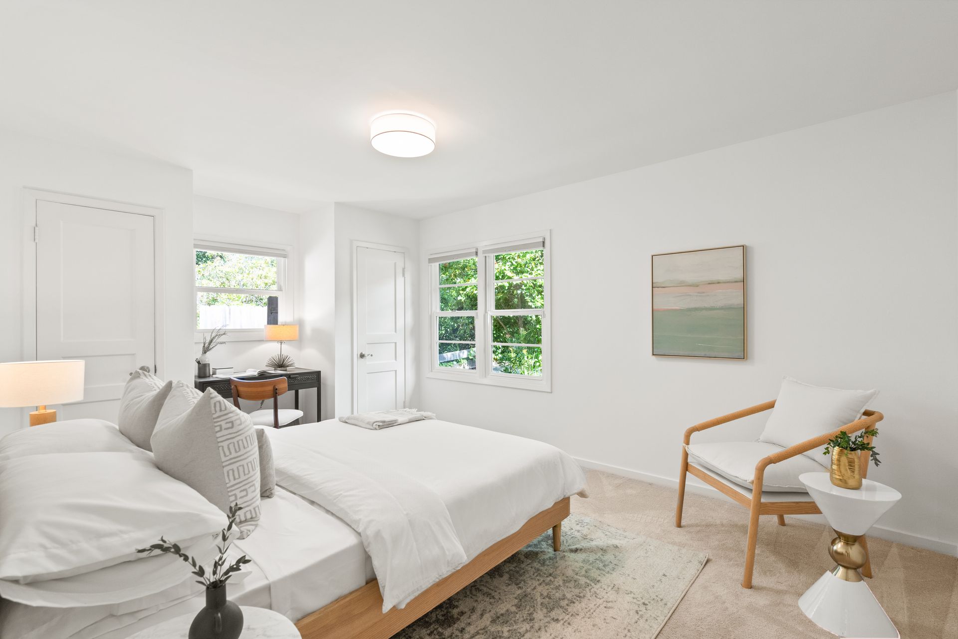 A bedroom with a bed , chair , table and window.