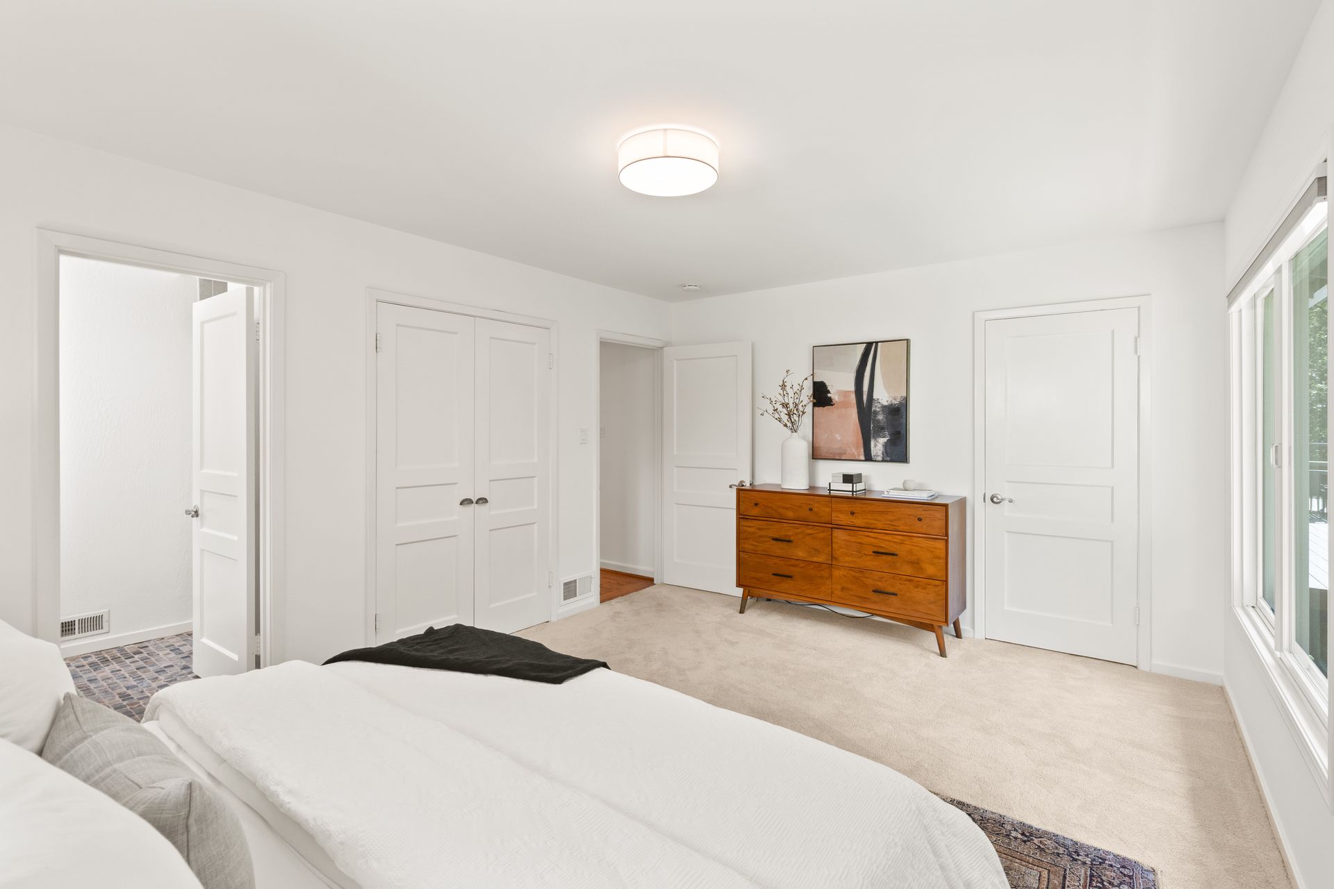 A bedroom with a bed and a dresser.