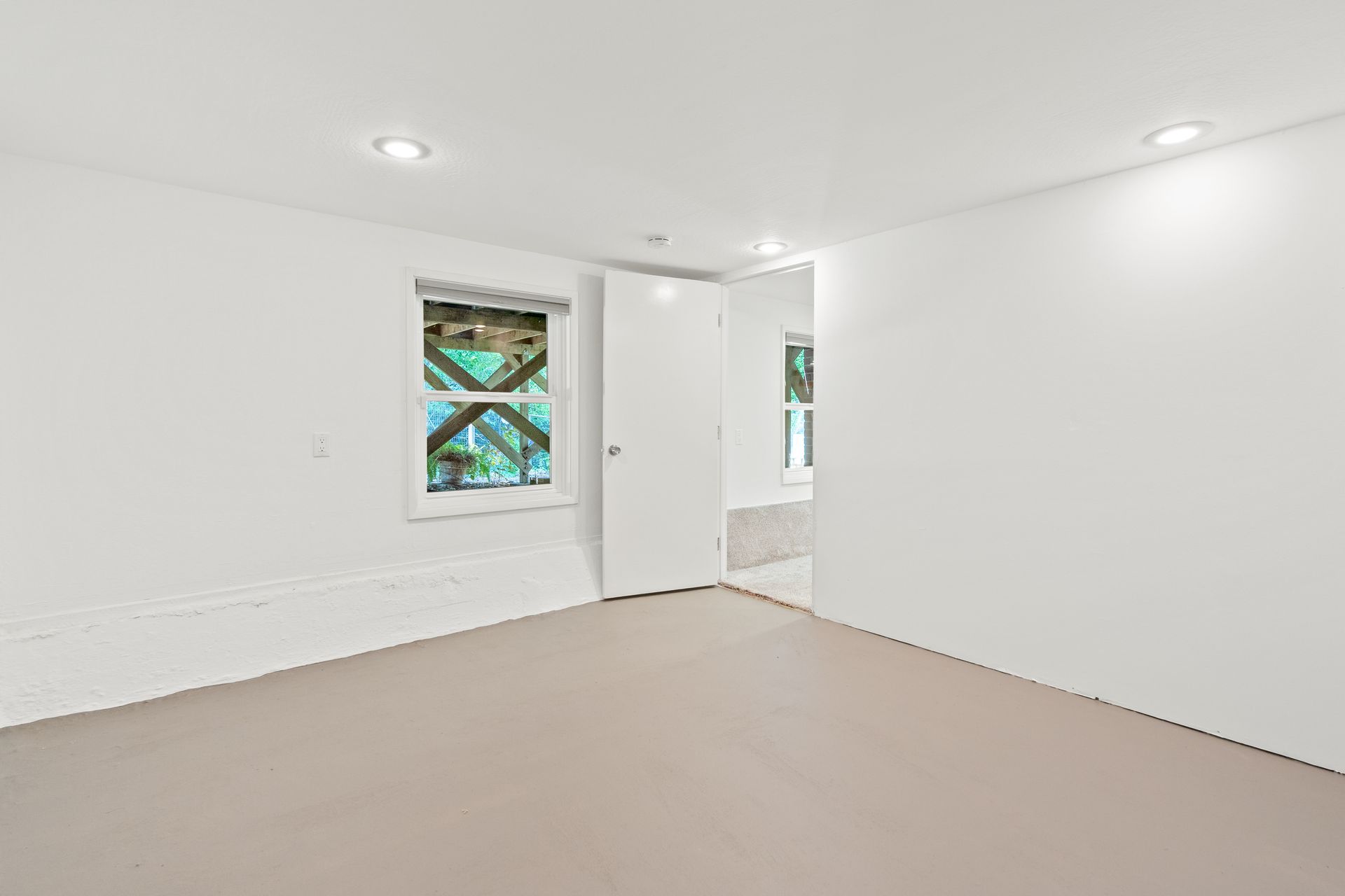 An empty room with a window and a door.