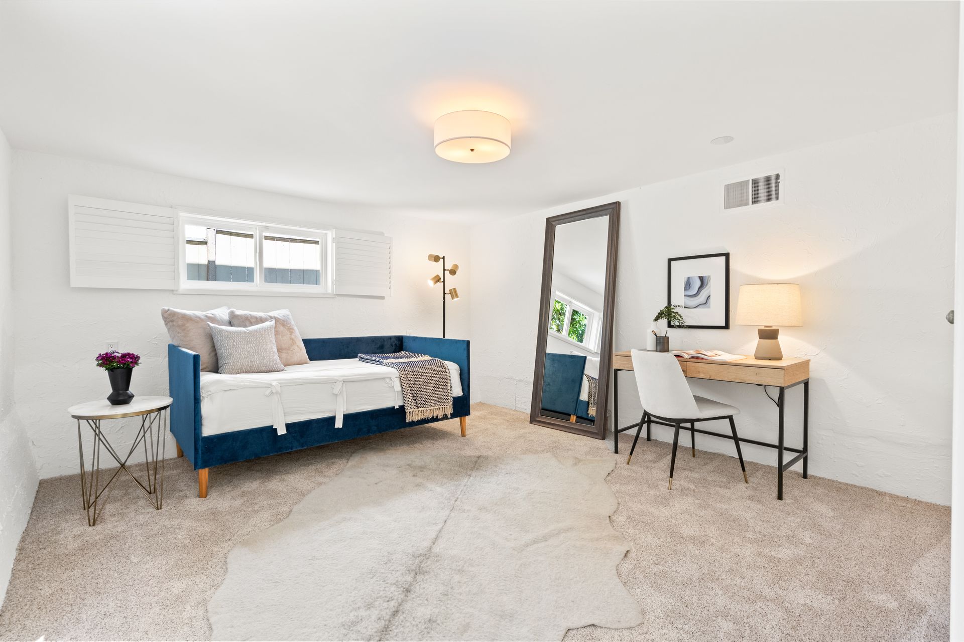 A room with a blue couch and a desk