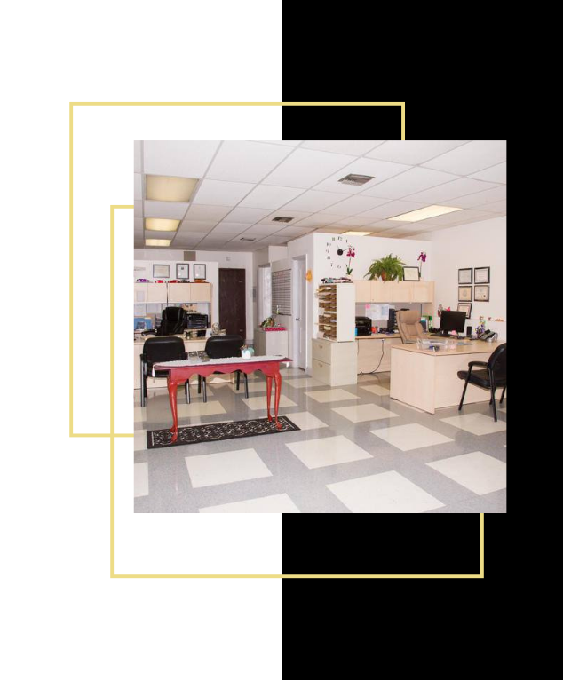 Office interior with desks, chairs, and a patterned tile floor.