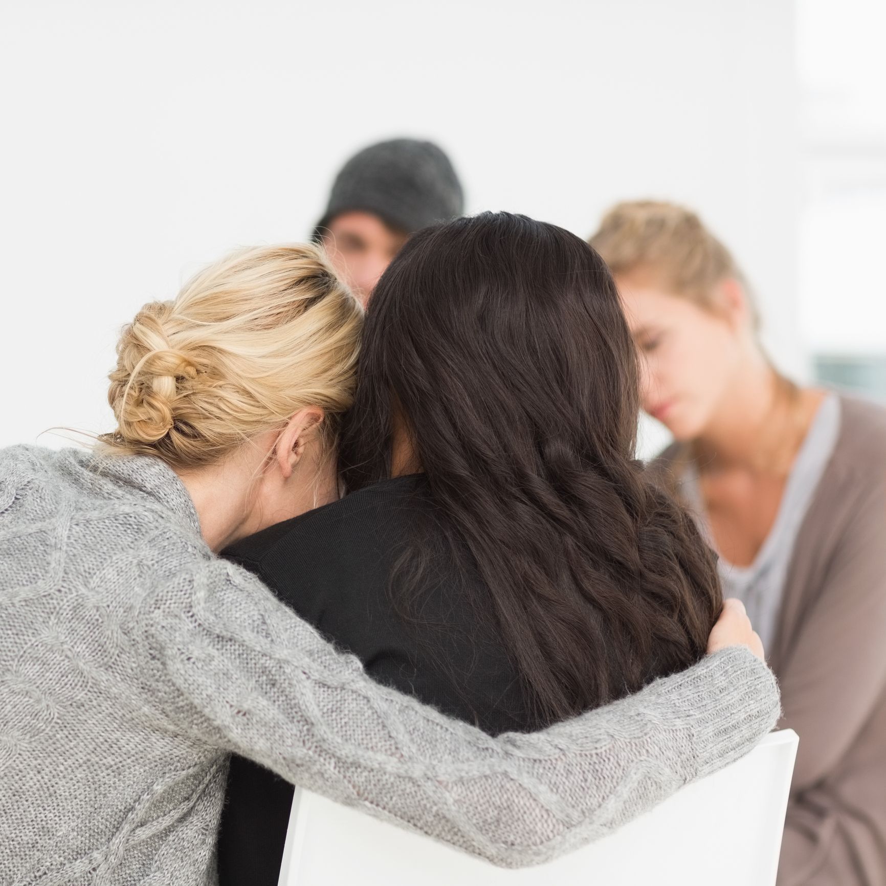 A group of women are hugging each other in a circle