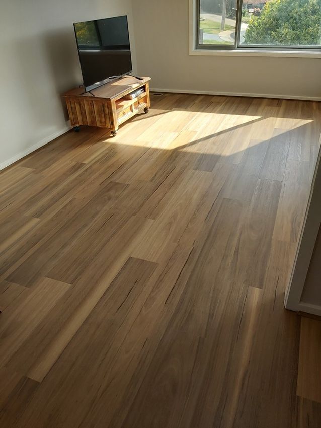 A Living Room With a Wooden Floor and a Television on a Stand — Canberra Floor Coverings in Googong, NSW