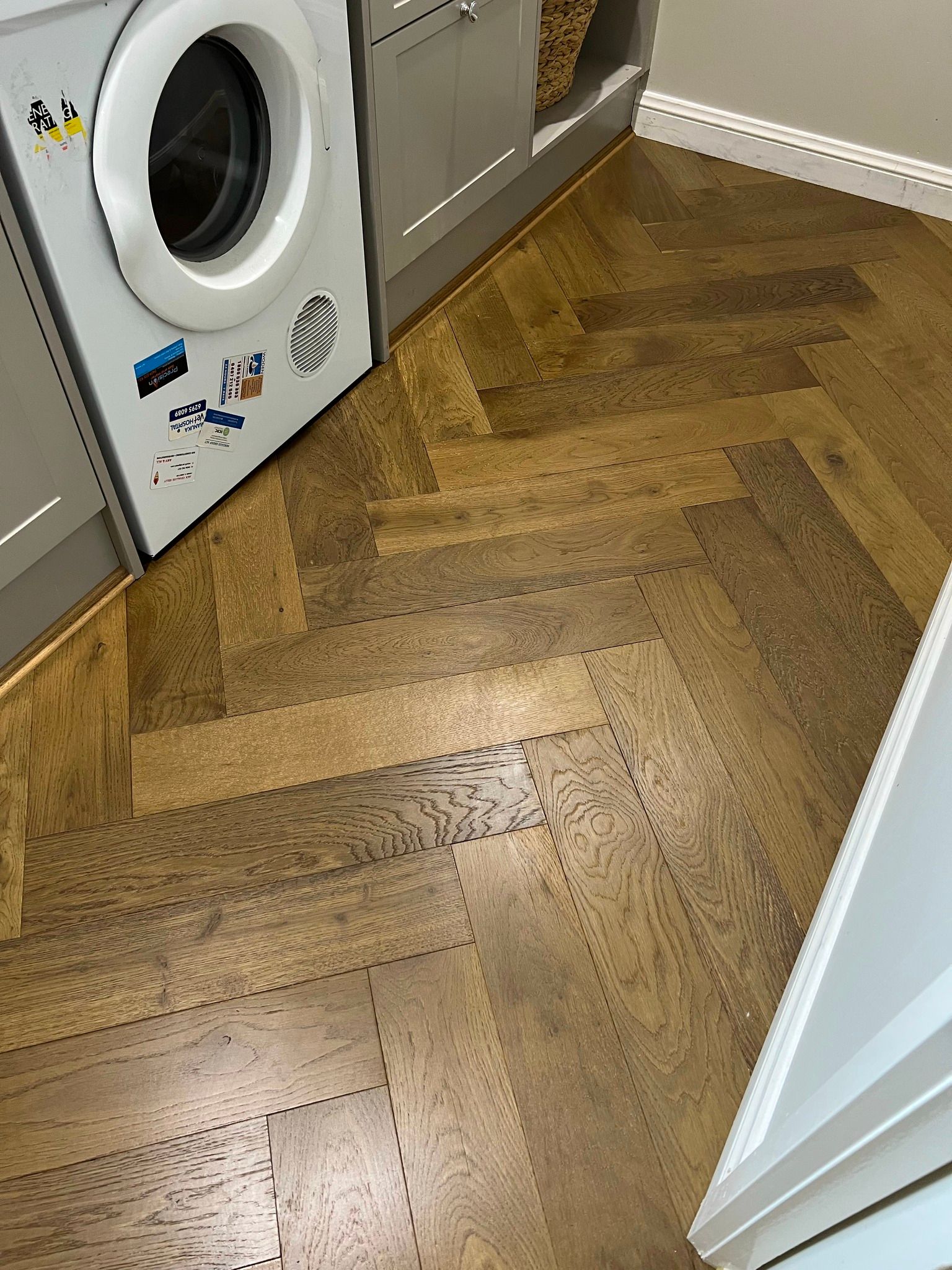 Laundry Room with A Herringbone Pattern Floor, Washing Machine on The Left — Canberra Floor Coverings in Queanbeyan West, NSW