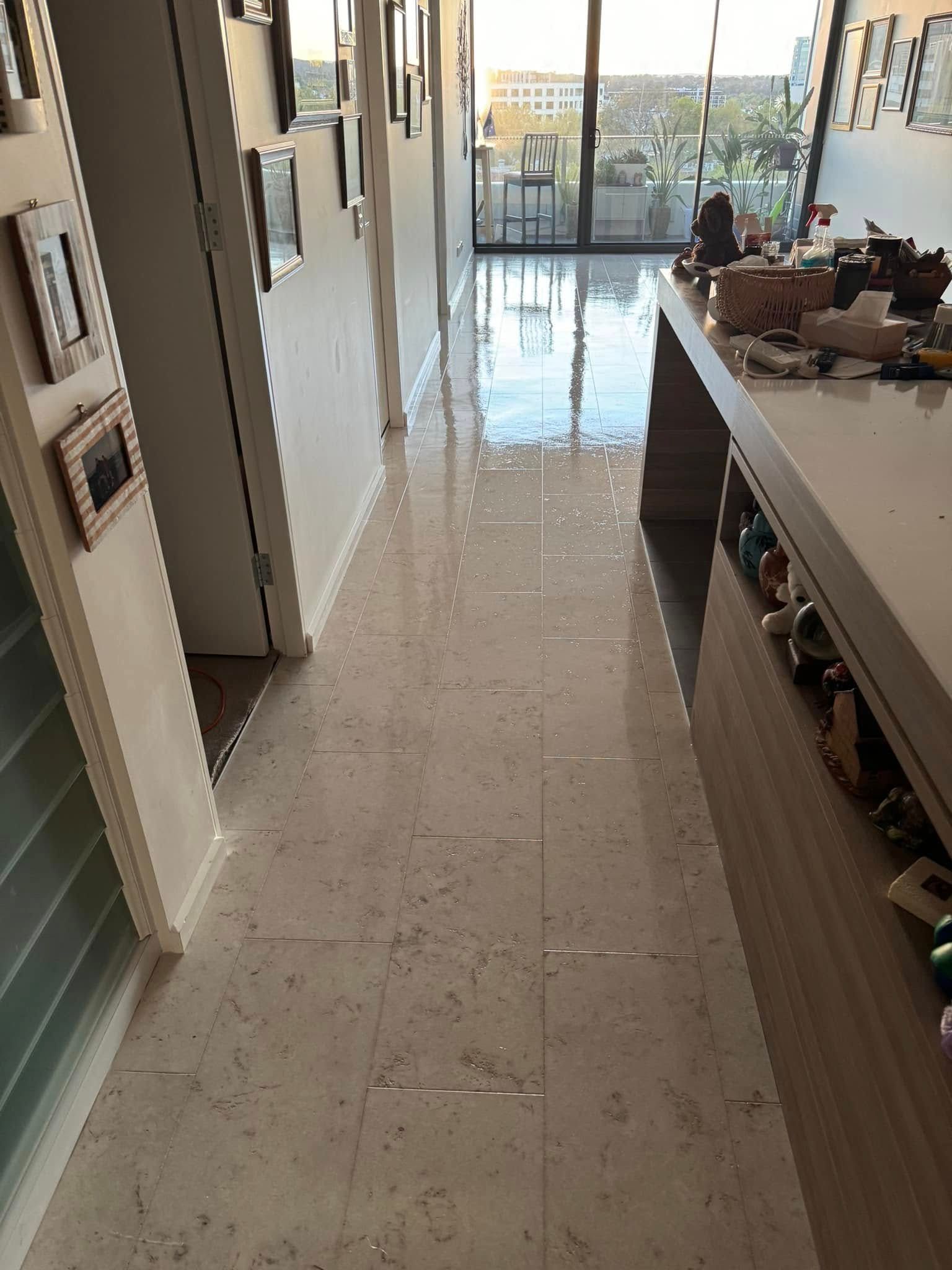 Long Hallway with Marble Floors, Door on The Left, and A Long Kitchen Island with Items on Top to The Right — Canberra Floor Coverings in Queanbeyan West, NSW