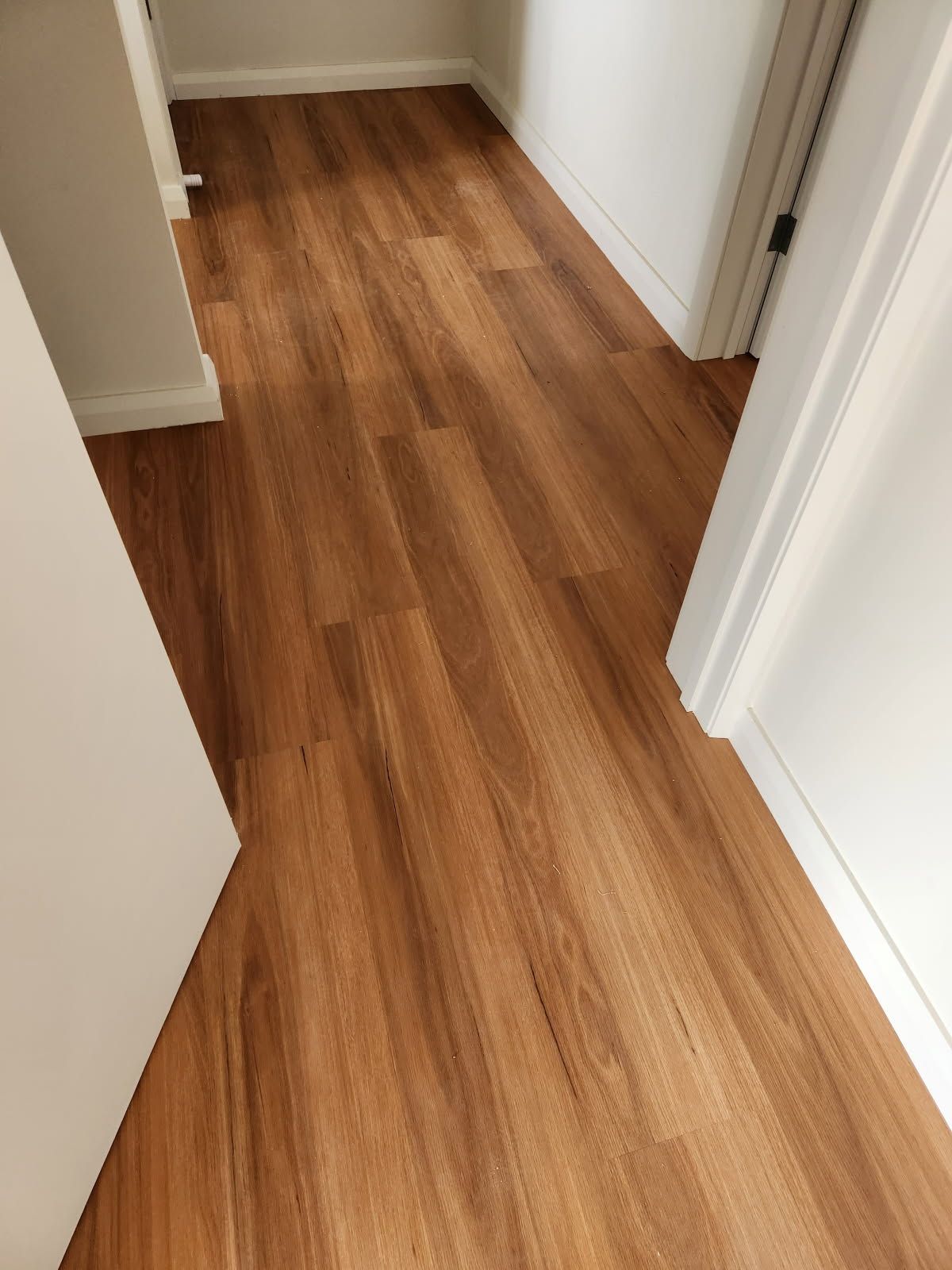 Wooden-Look Flooring in A Hallway with White Walls and Trim — Canberra Floor Coverings in Queanbeyan West, NSW