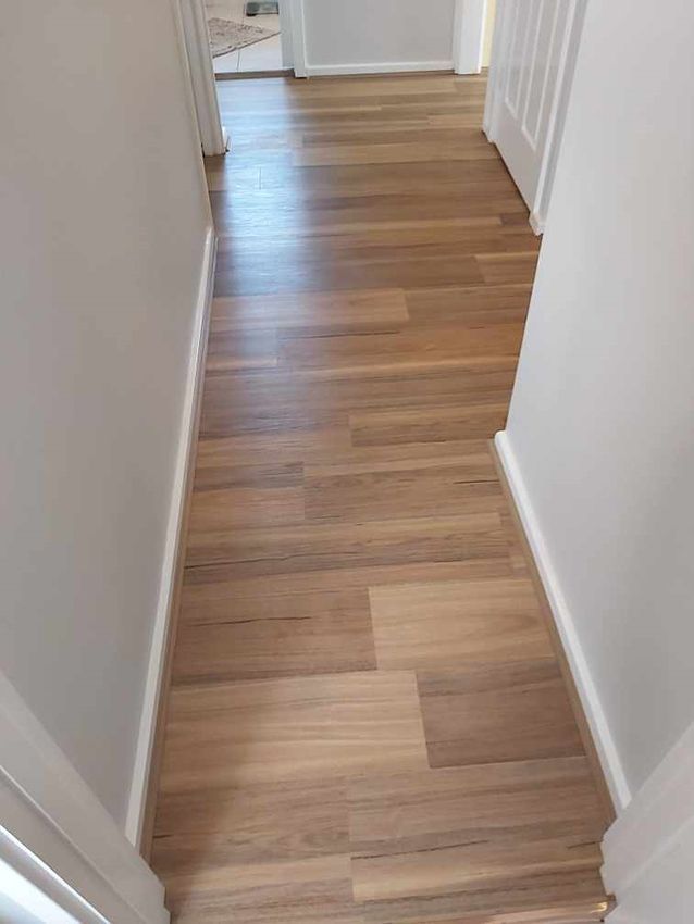 A Hallway With a Wooden Floor and Stairs Leading to a Door — Canberra Floor Coverings in Bungendore, NSW