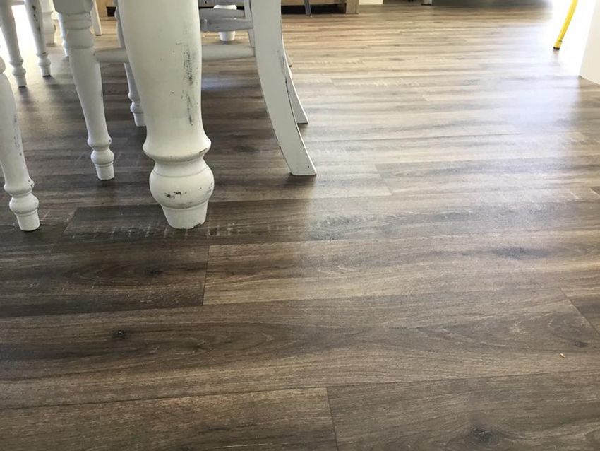 A Wooden Floor With a Table and Chairs on It — Canberra Floor Coverings in Googong, NSW