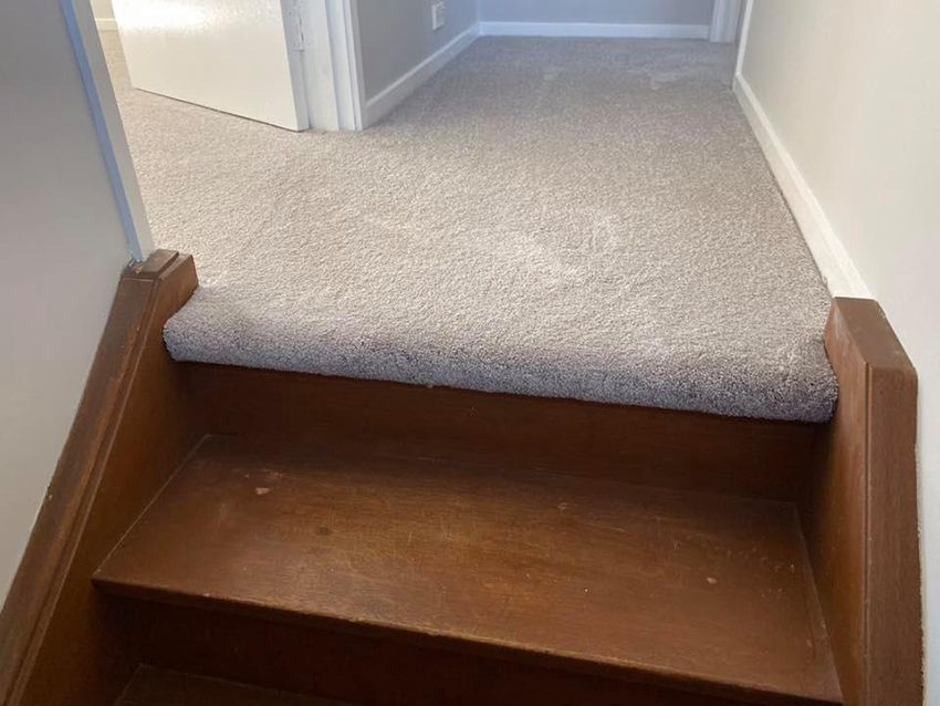 A Staircase With a Wooden Railing and a Carpeted Floor — Canberra Floor Coverings in Googong, NSW