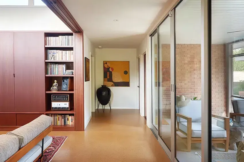 A Living Room With a Couch, Chair, and Bookshelf — Canberra Floor Coverings in Queanbeyan, NSW