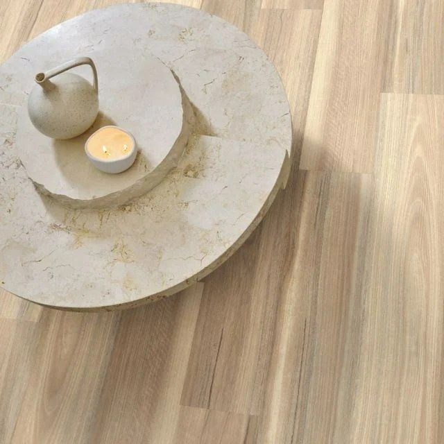 Round Stone Coffee Table With White Objects on Light Wood Flooring — Canberra Floor Coverings in Queanbeyan West, NSW