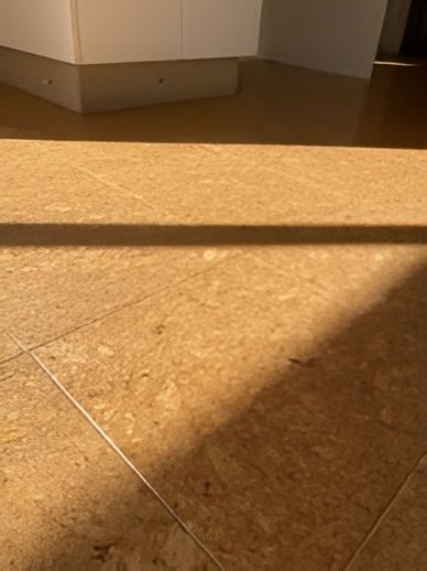 Brown Cork Tile Floor With a Long Shadow Cast Across It — Canberra Floor Coverings in Queanbeyan West, NSW