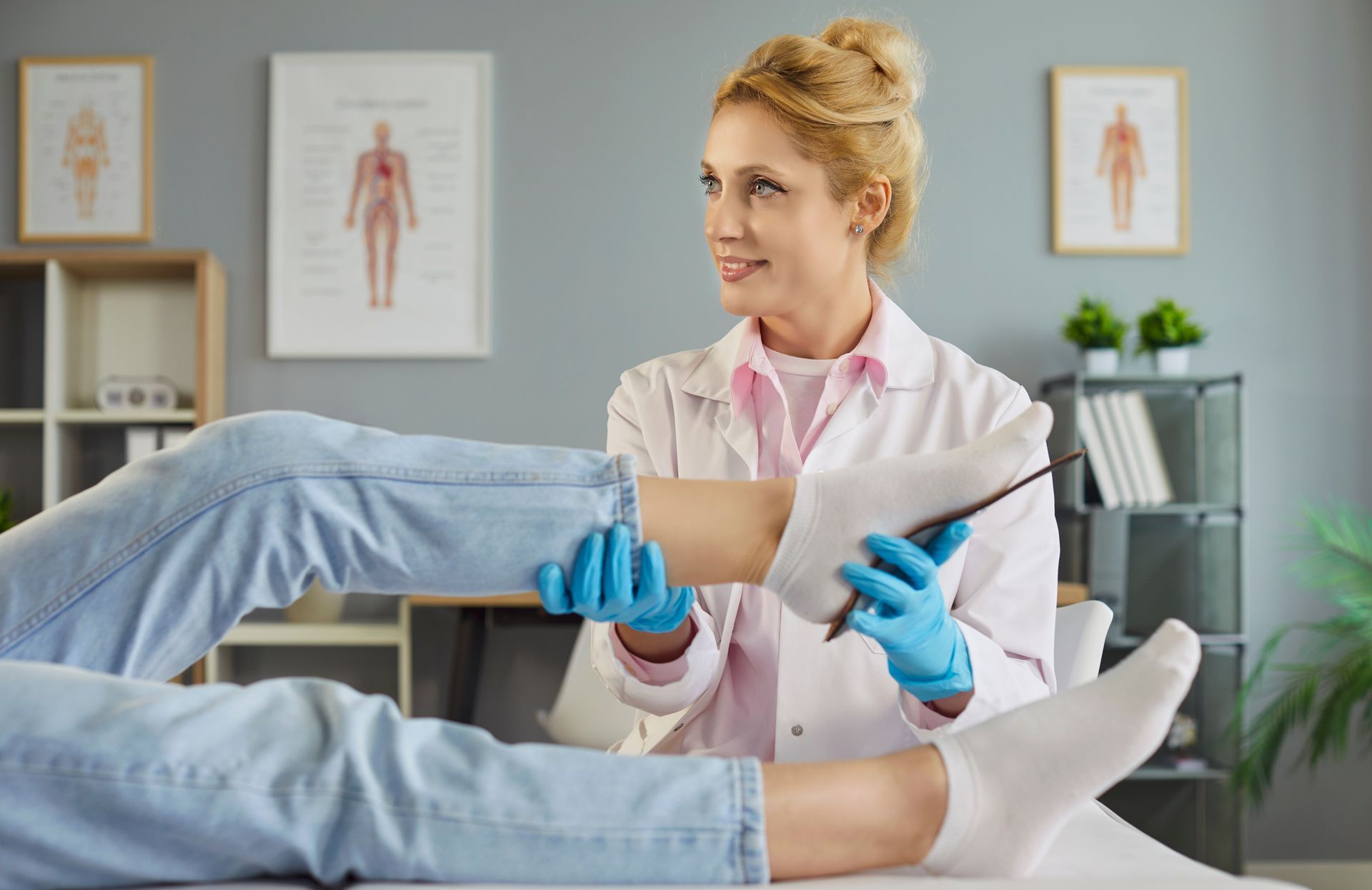 Doctor examining a patient's leg with an instrument, medical office setting.