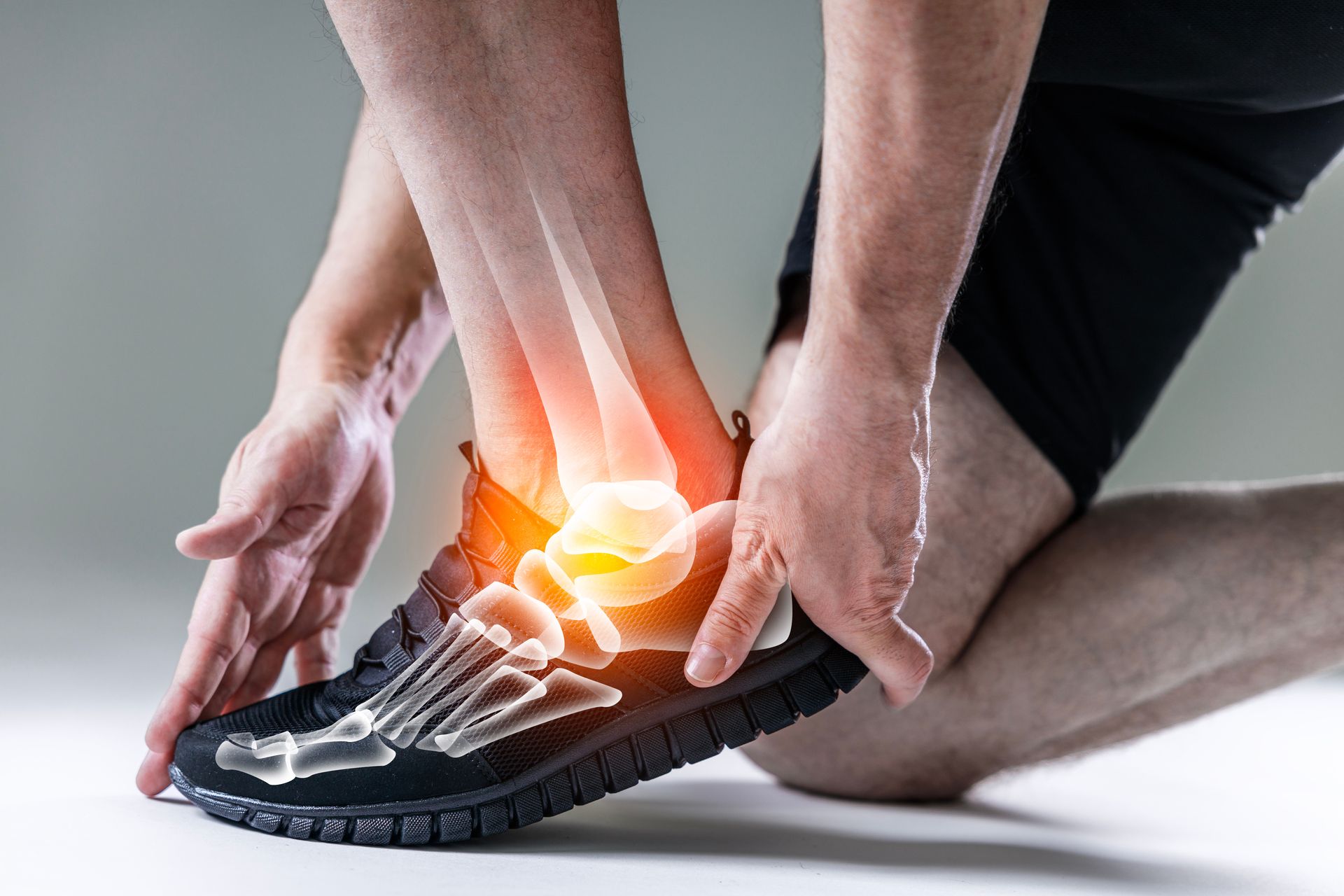 Person holding their ankle, indicating pain, with a glowing illustration of bones showing a possible injury.