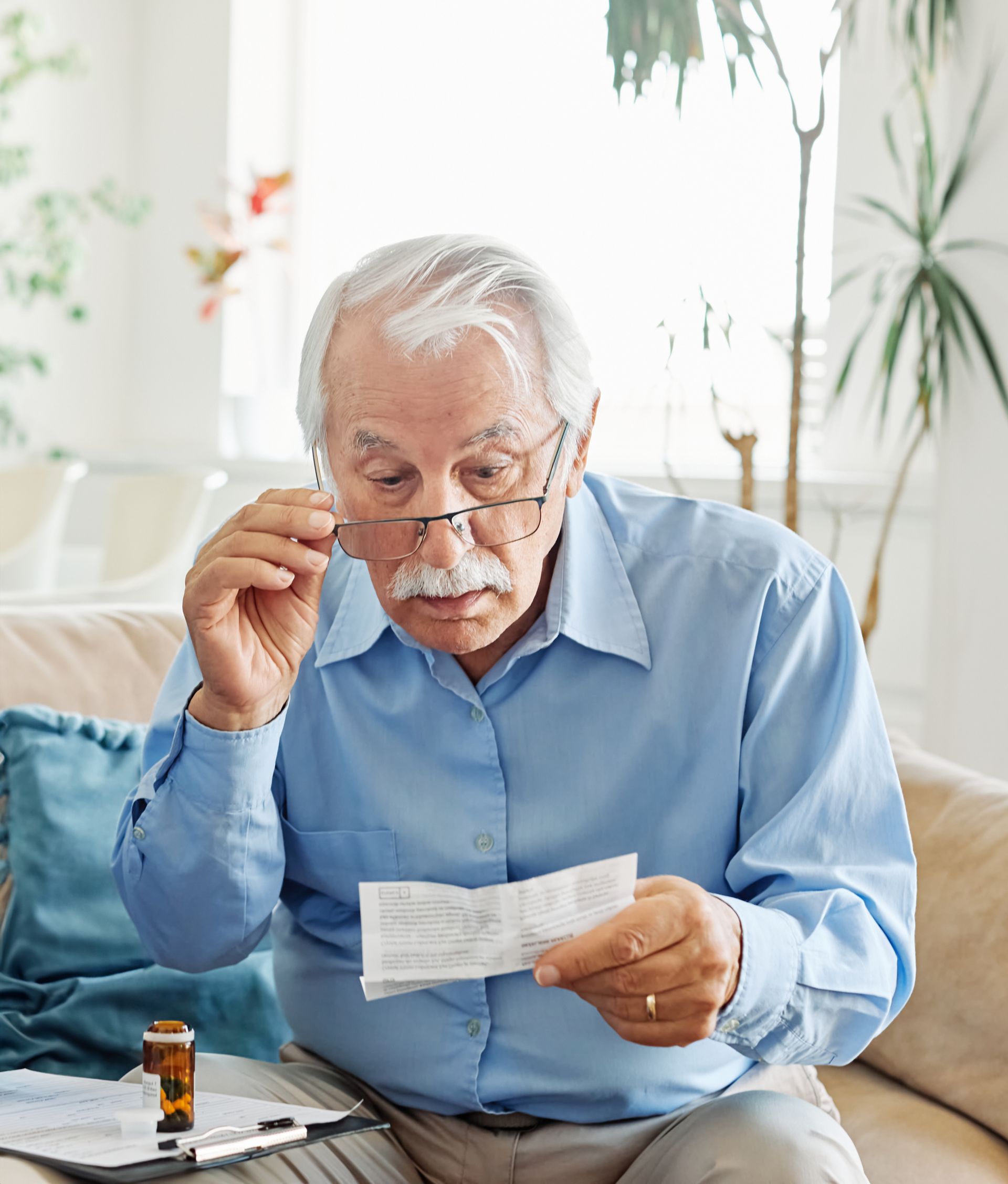 A young man is helping an older man with his medication.