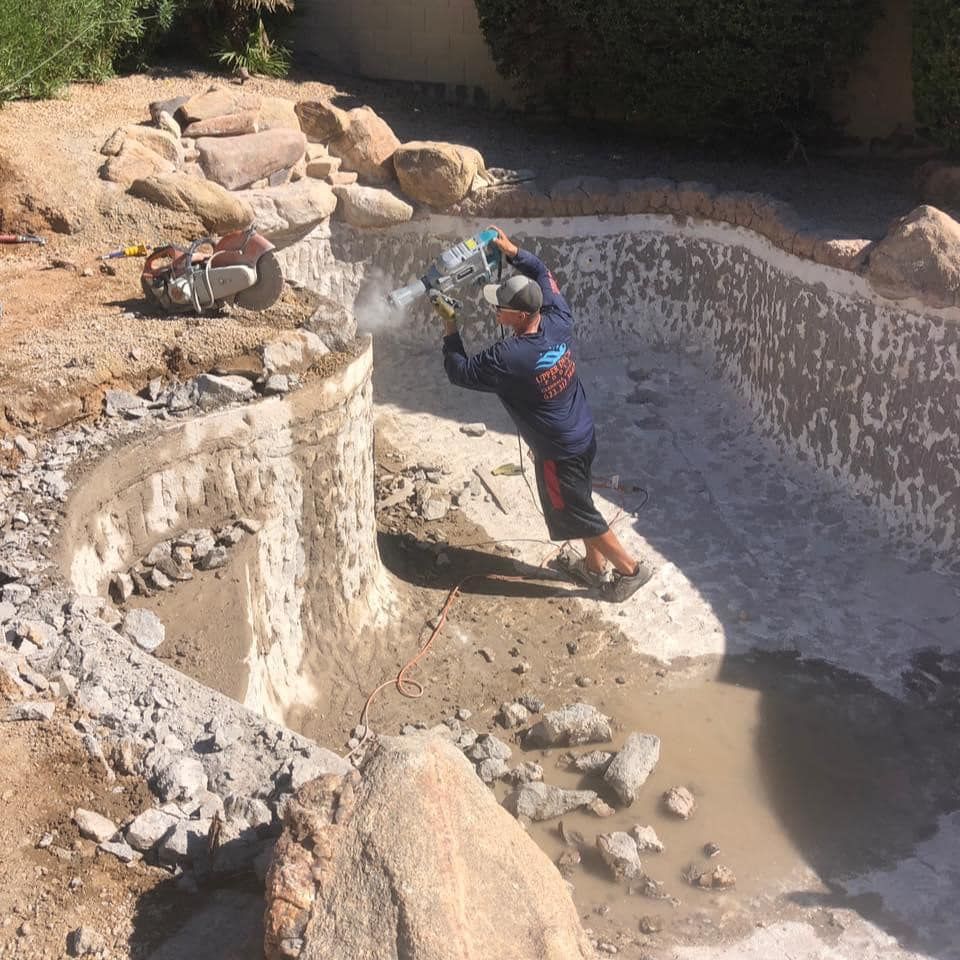 A man is working on a swimming pool with a chainsaw