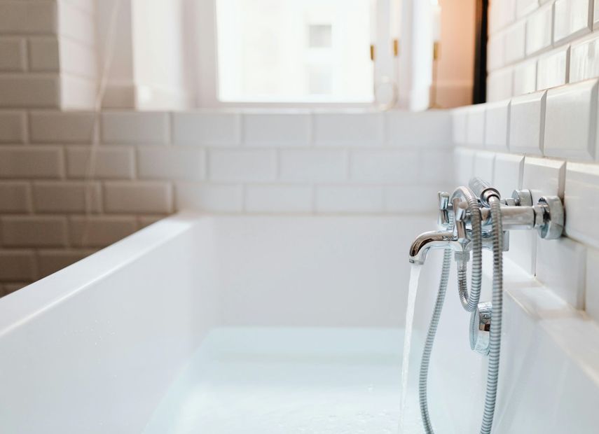 A bathtub with a shower head attached to it in a bathroom.