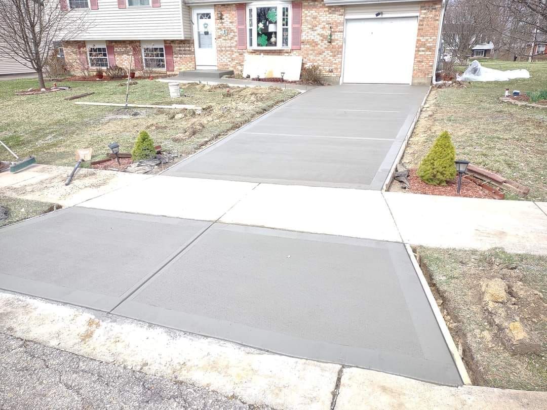 A concrete driveway is being built in front of a house.
